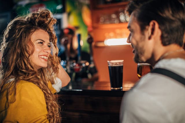 <p>A couple drinking beer at a bar – something a person with celiac disease is not about it do </p>