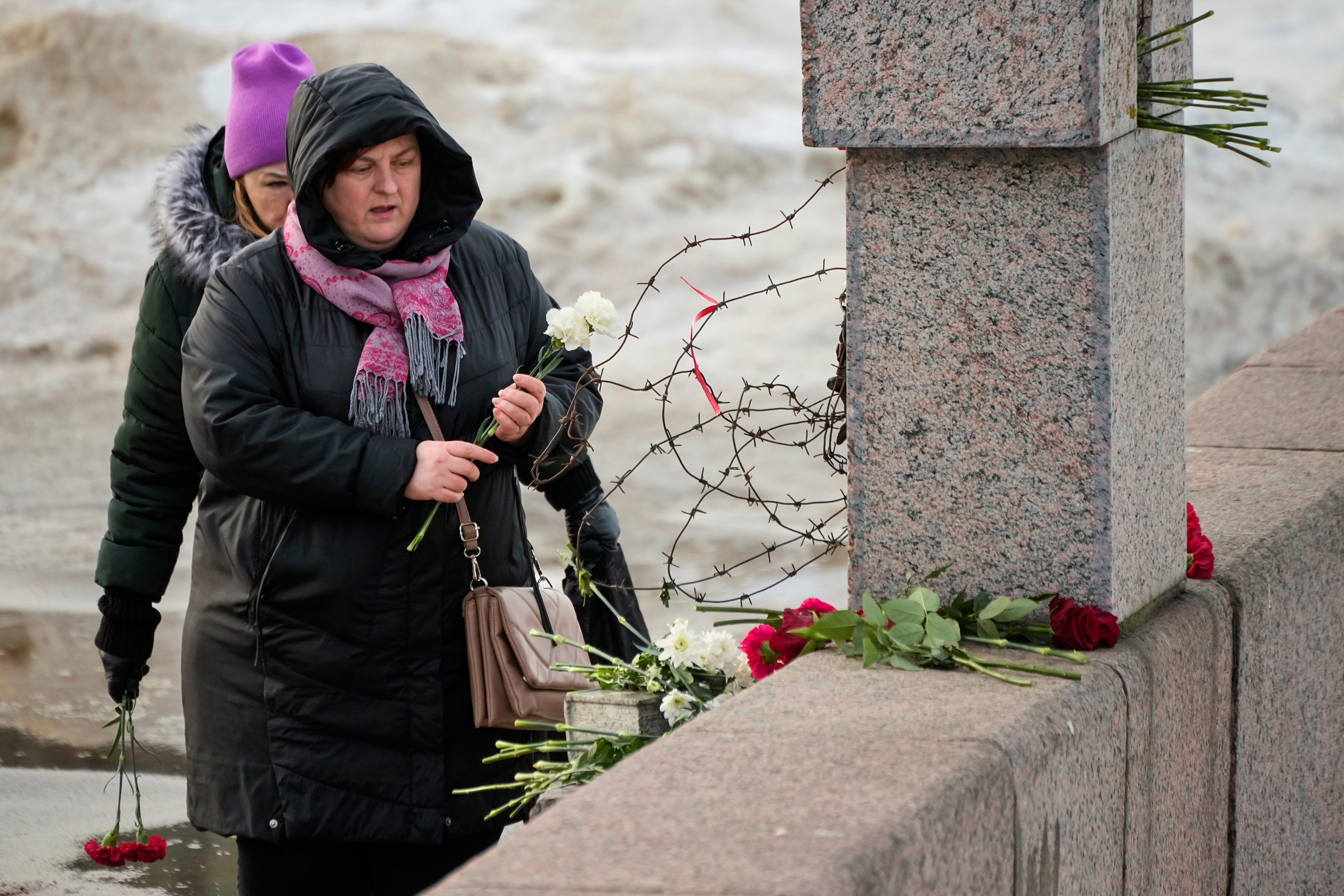 Women lay flowers at the Memorial to Victims of Political Repression to pay respect to Alexei Navalny in St Petersburg, Russia, Tuesday, 20 February 2024