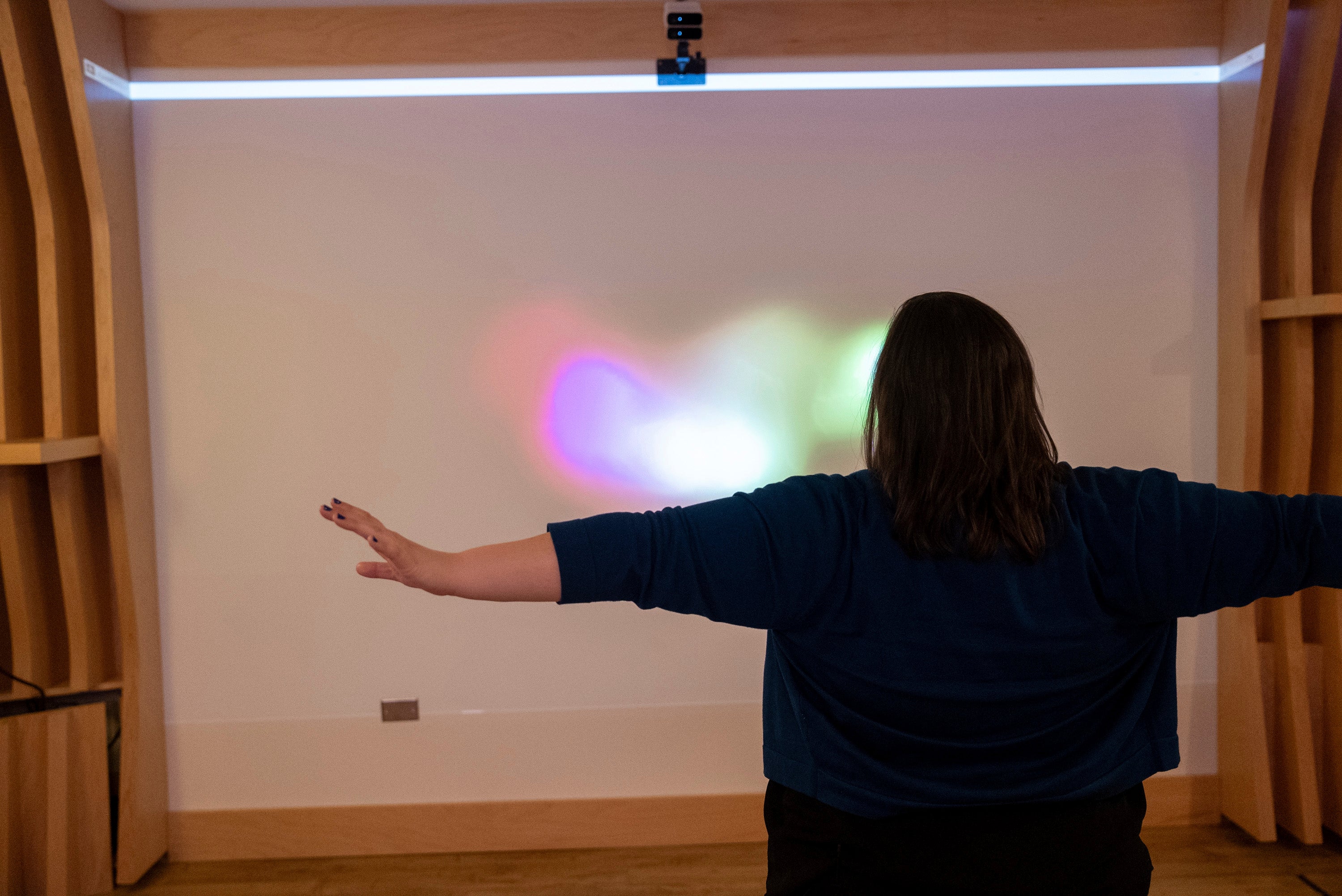 Emily Hollenbeck, a deep brain stimulation therapy patient, demonstrates how she makes circles in the air with her arms