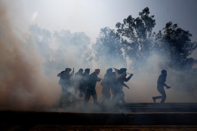 <p>Farmers, who are marching towards New Delhi to press for better crop prices promised to them in 2021, run for cover amidst tear gas fired by police to disperse them at Shambhu barrier, a border crossing between Punjab and Haryana states, India, 21 February 2024</p>
