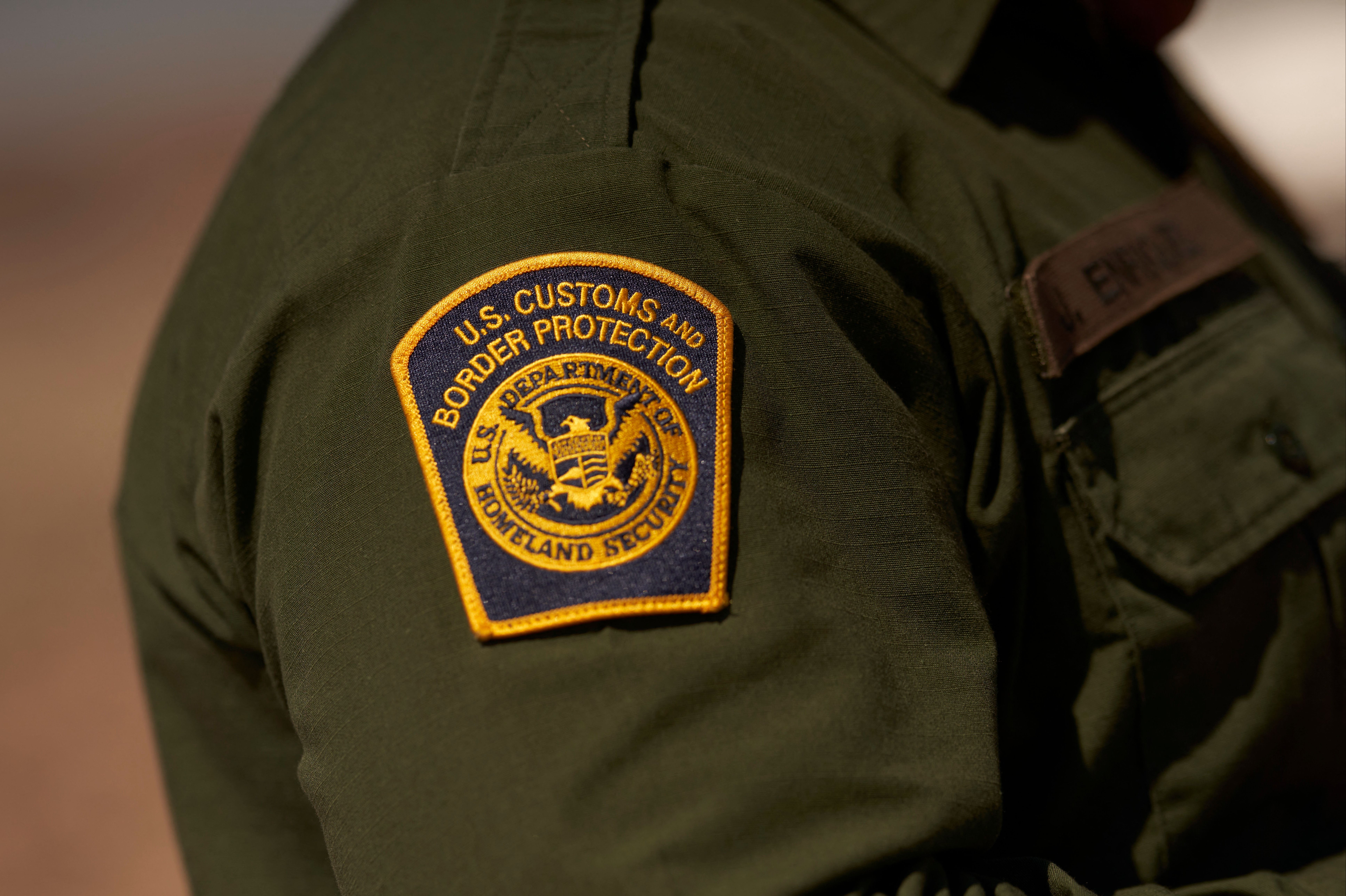 A US Customs and Border Protection patch is seen on the arm of an agent in the Jacumba mountains on October 6, 2022 in Imperial County, California