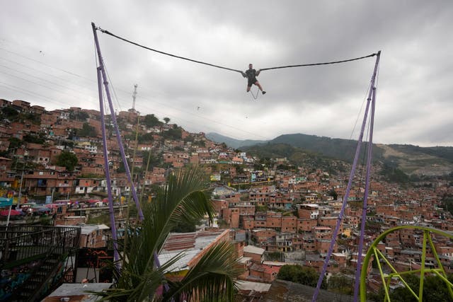 <p>A tourist rides a bungee jump in the Comuna 13 neighborhood of Medellin, Colombia</p>