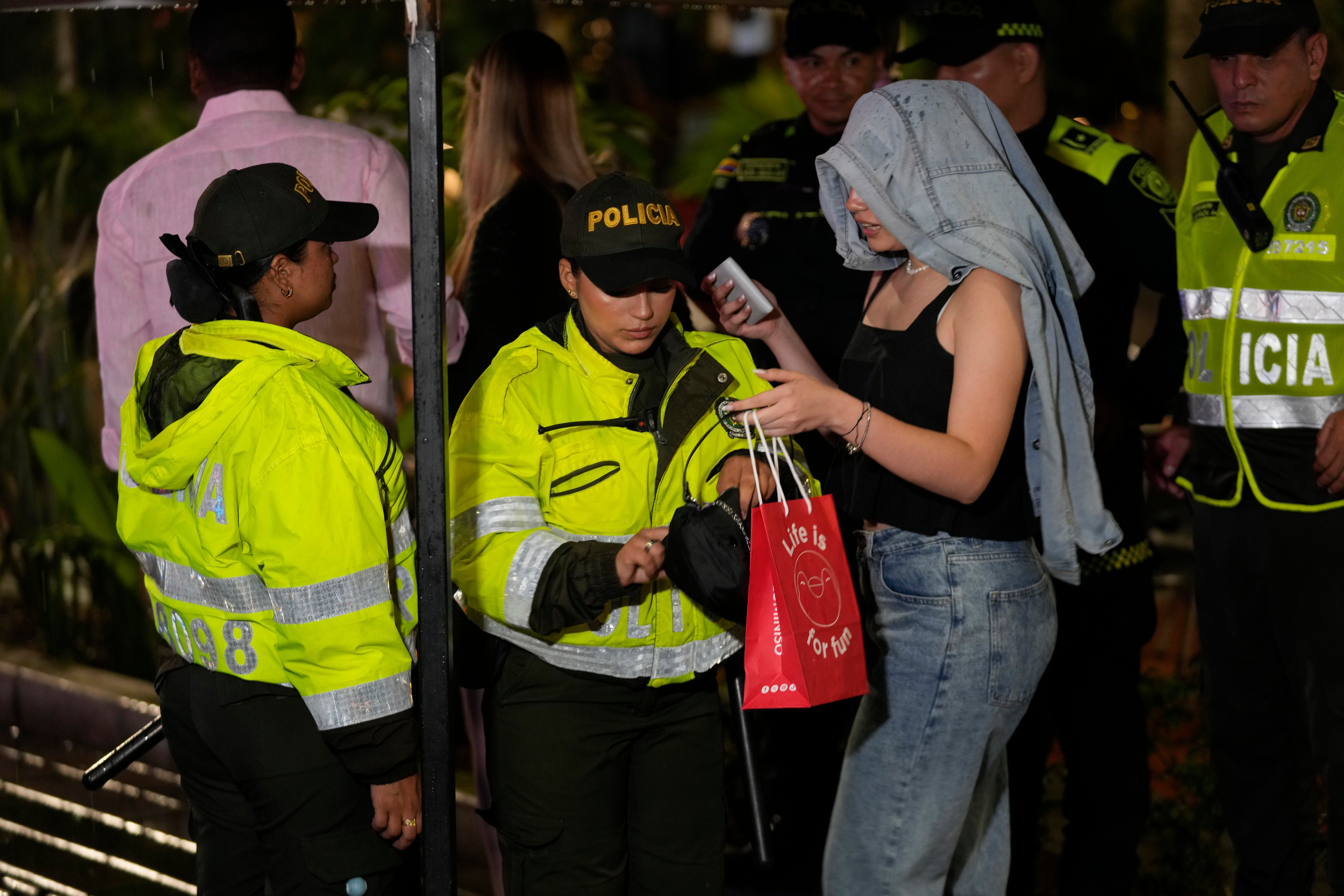Police ask a woman for proof of age at a checkpoint at an entrance to Lleras Park during an operation to enforce a curfew