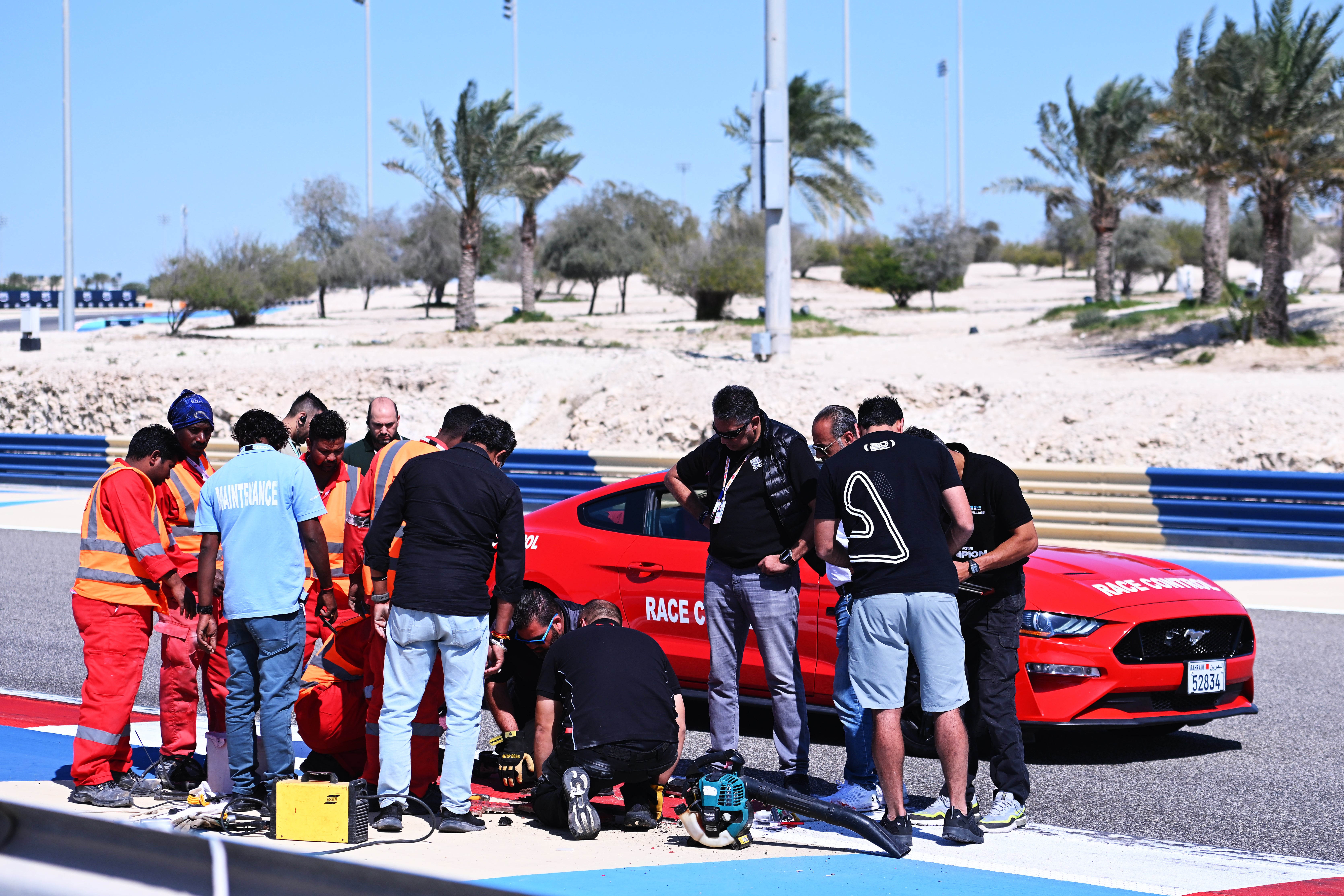 <p>Circuit officials inspect the loose drain cover in Bahrain</p>