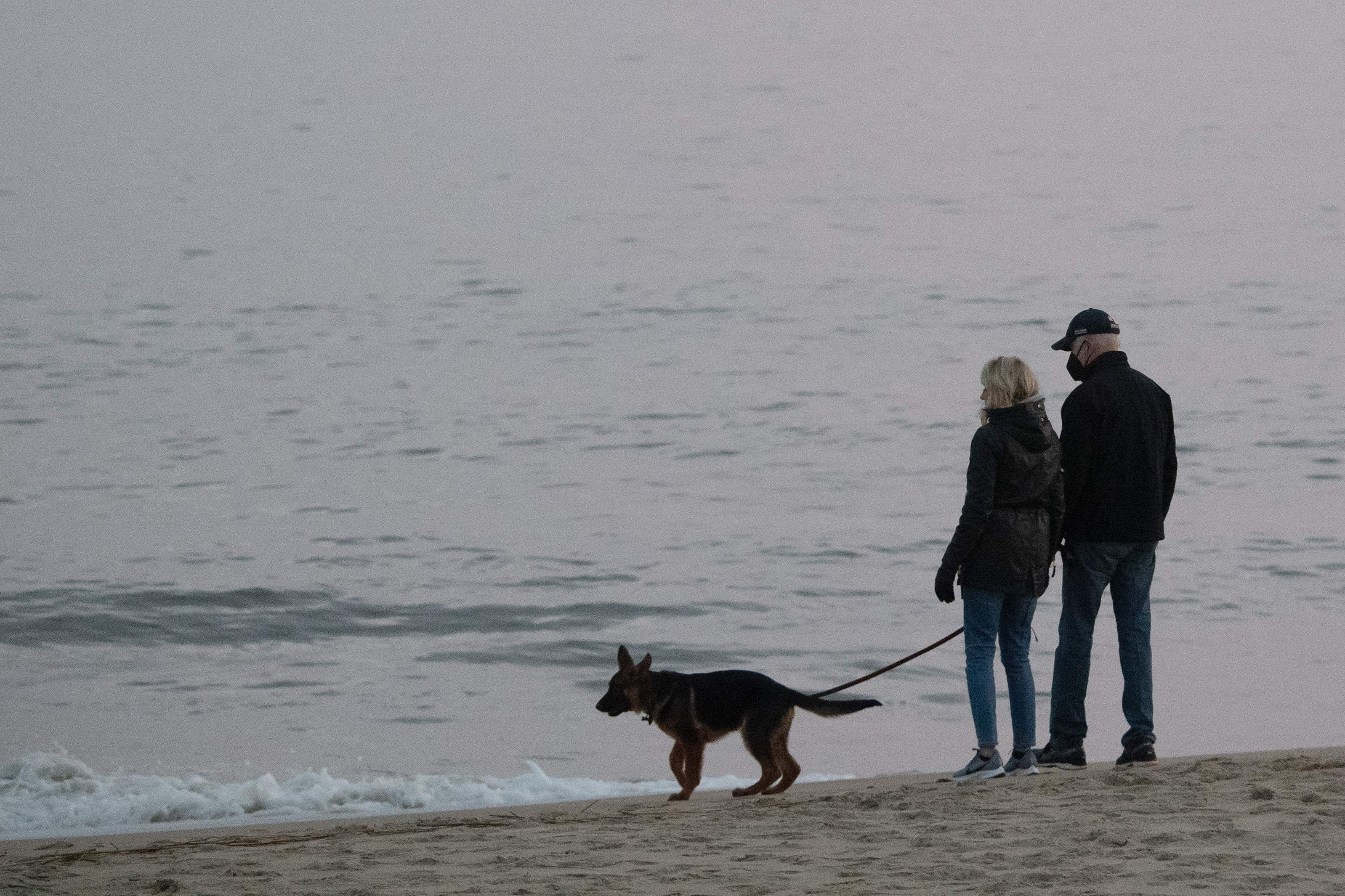 President Biden and his wife Jill walk their dog Commander