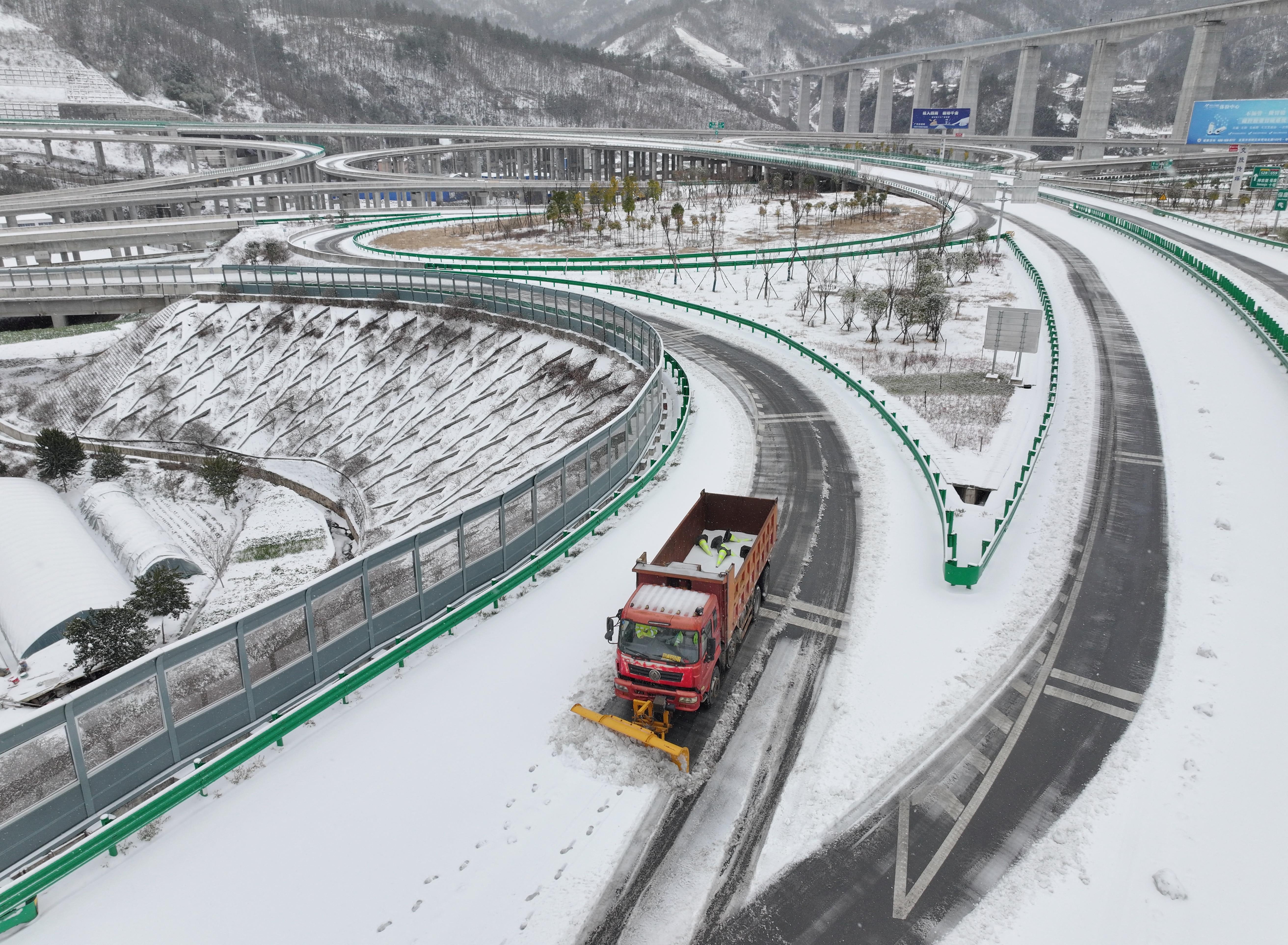 A vehicle removing snow from a highway following snowfall in Baokang