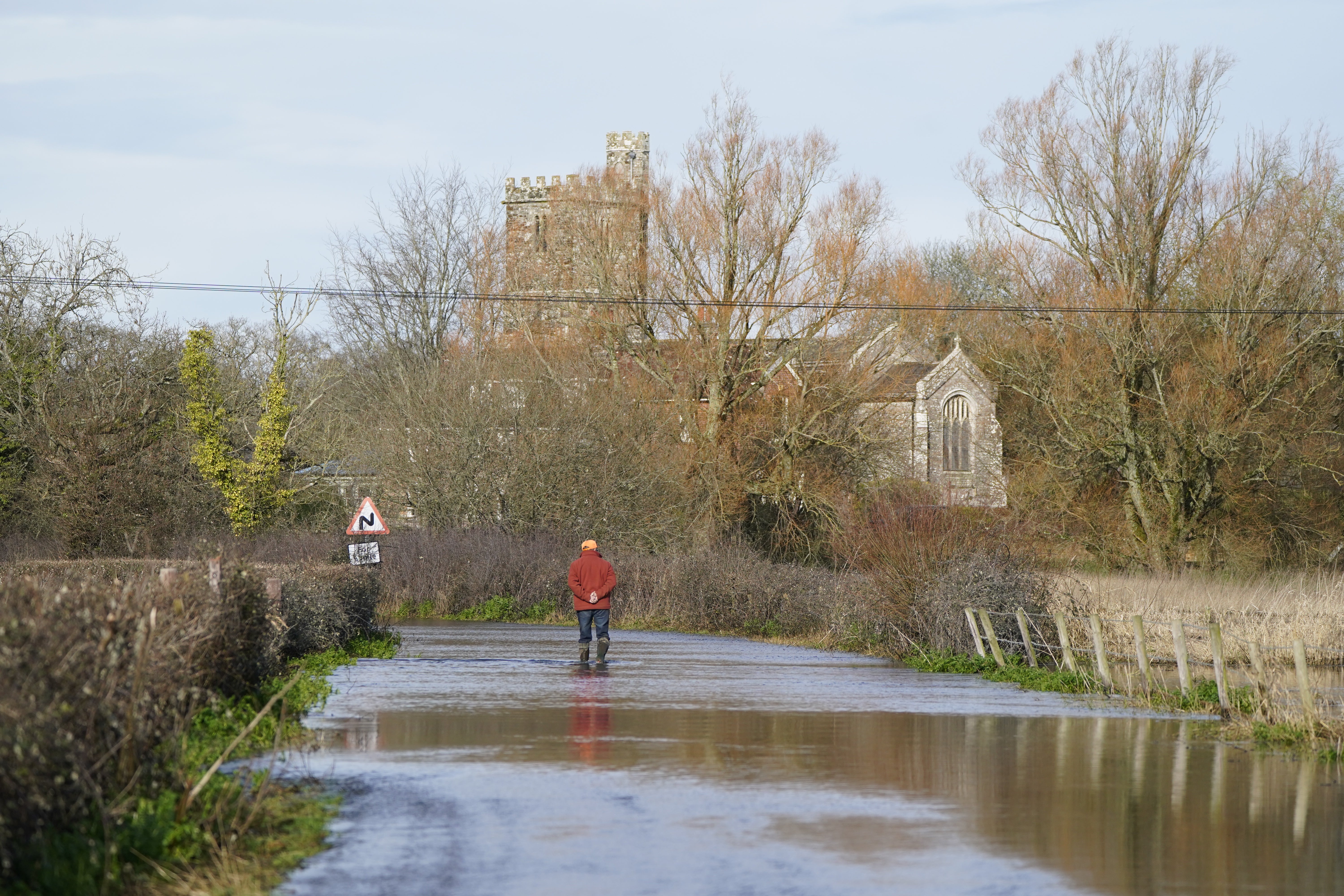 A man looks at floodwater in Harbridge, Hampshire.