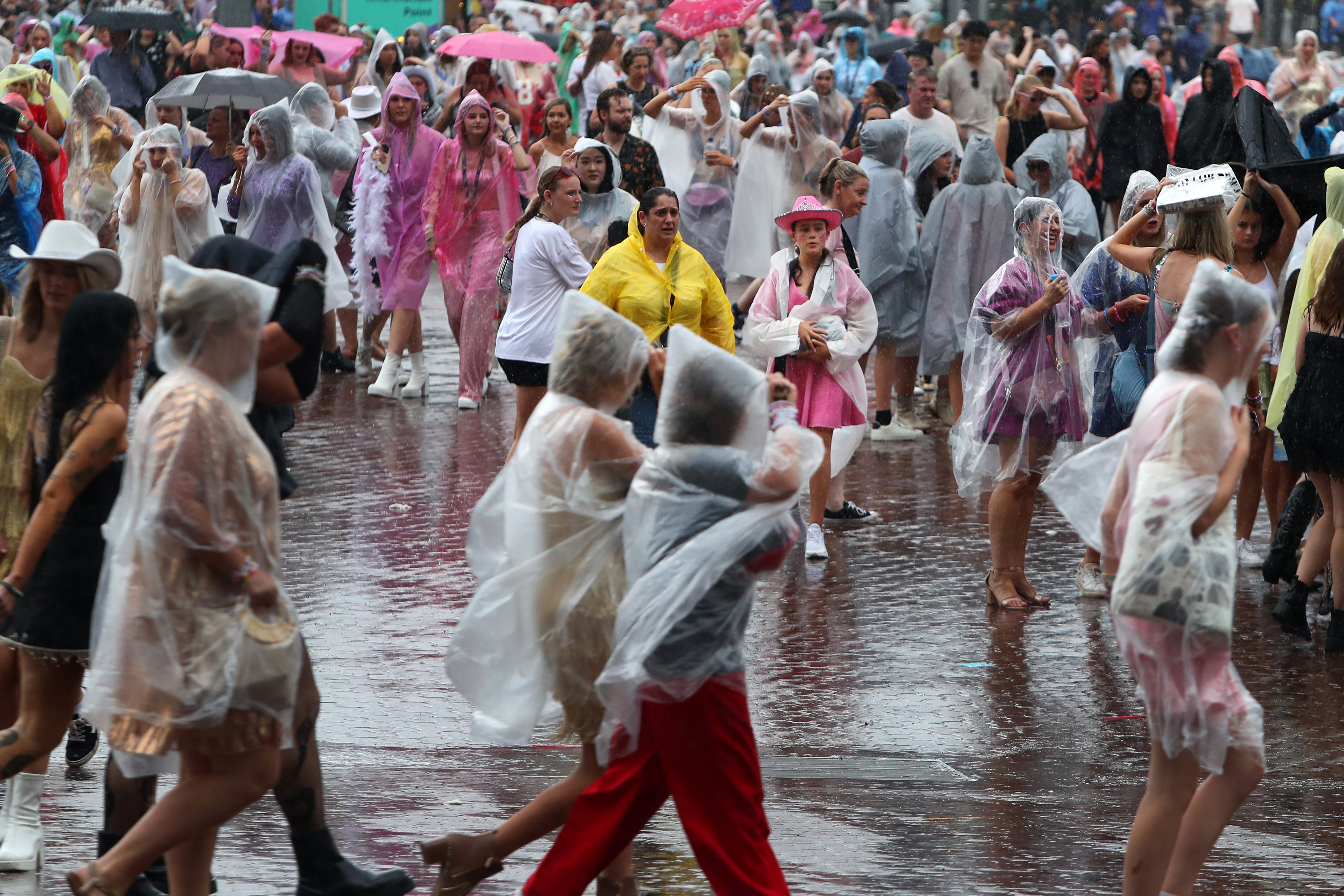 Swifties braving the wild weather in Sydney on their way to the Accor Stadium