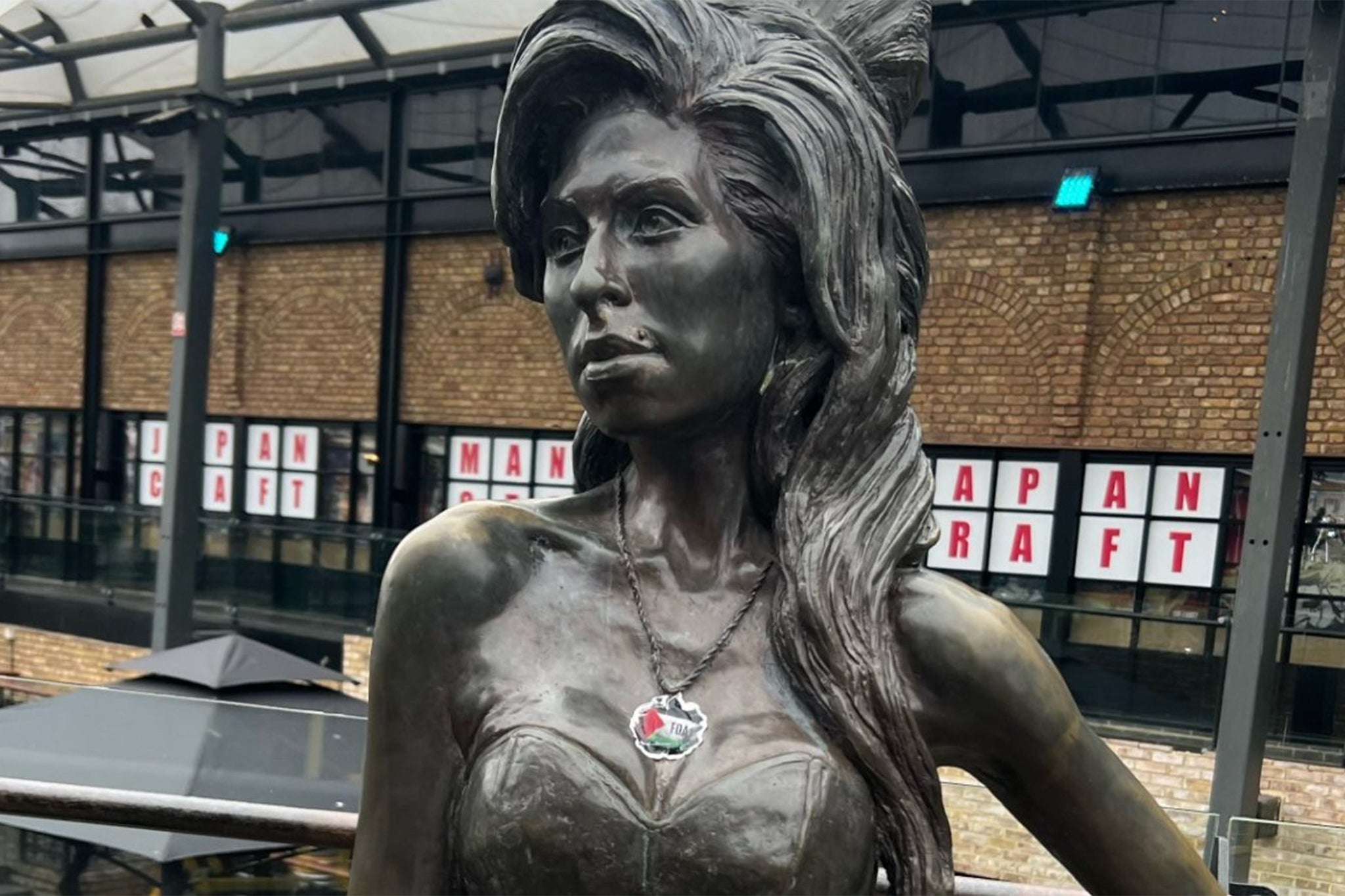 The statue of Amy Winehouse in Camden Market defaced with a sticker of the Palestinian flag