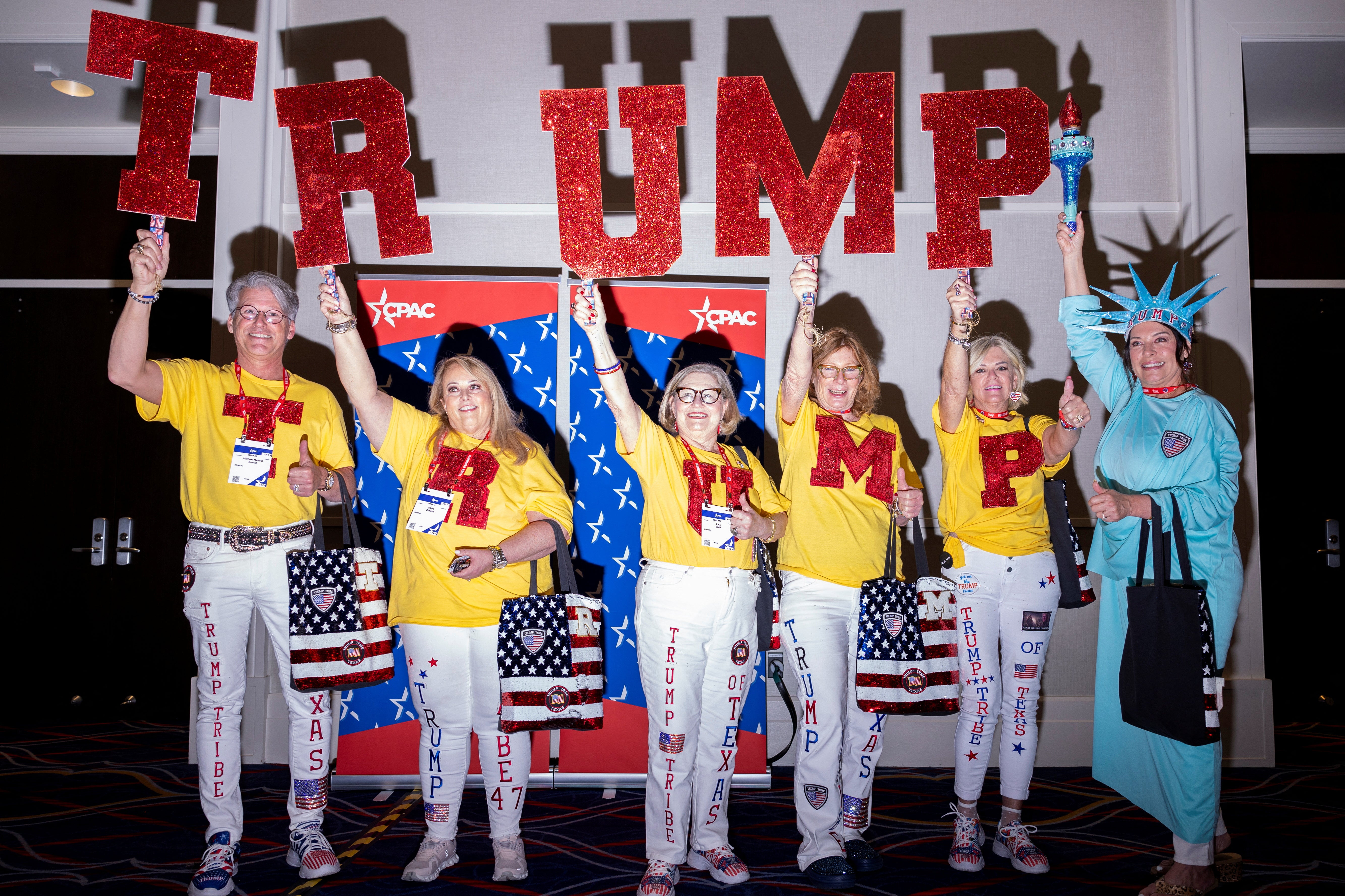 A group of Trump supporters hold up signs at the Conservative Political Action Conference (CPAC) annual meeting in National Harbor, Maryland, U.S., February 22, 2024