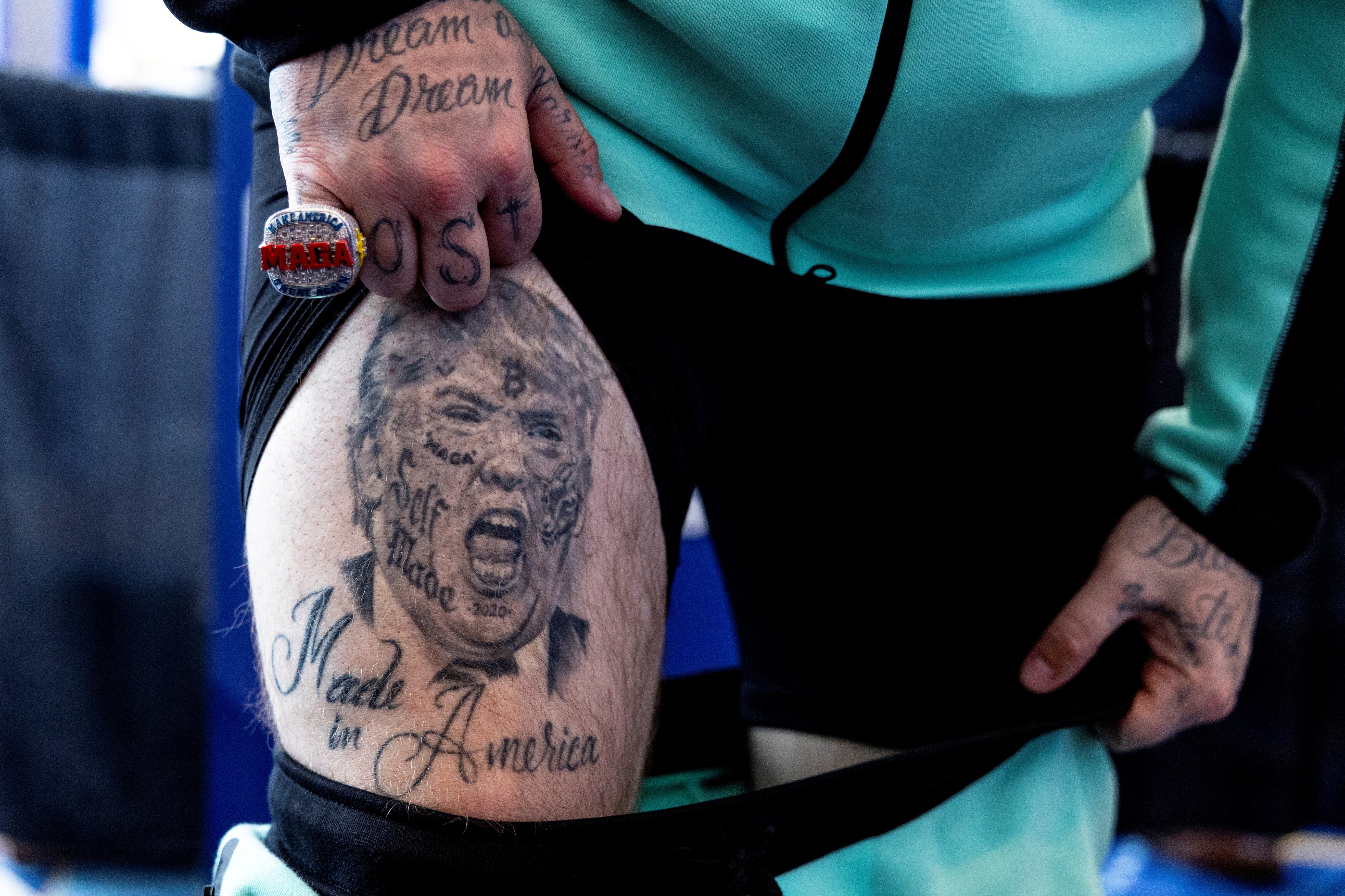 Rapper Forgiato Blow shows a person his Trump-themed tattoo at the Conservative Political Action Conference (CPAC) annual meeting in National Harbor, Maryland, U.S., February 22, 2024