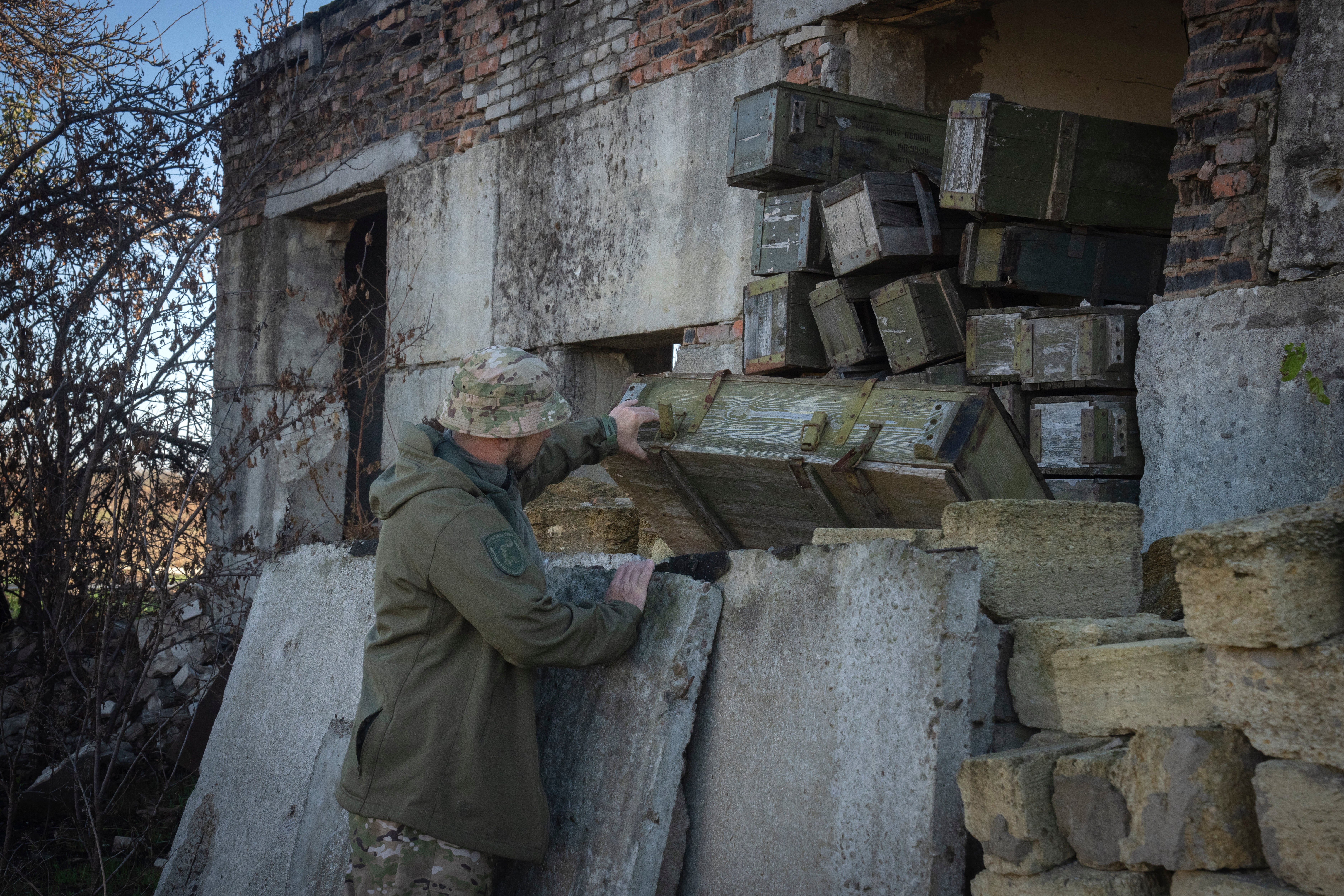 A sapper examines ammunition left by the Russian troops in the village of Kiseliovka close to Kherson, Ukraine