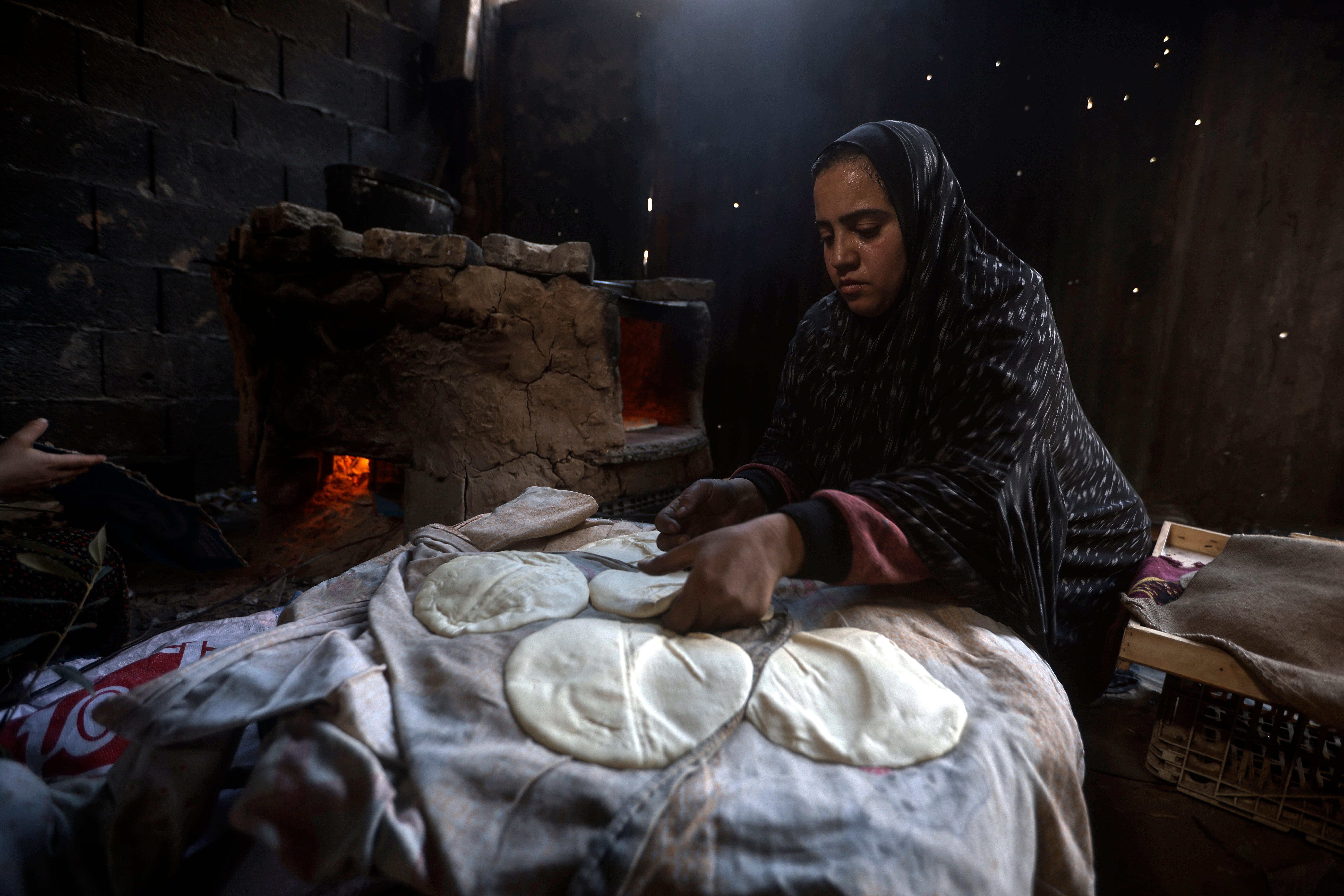 A Palestinian woman makes bread in Rafah, Gaza