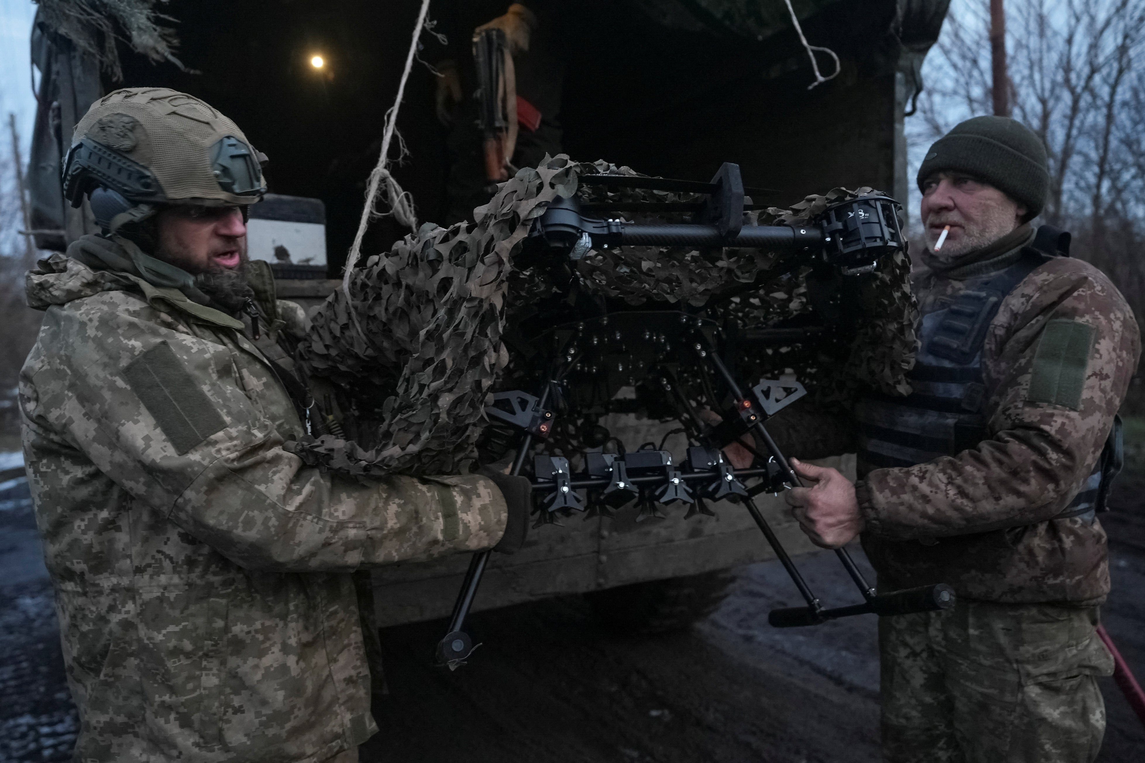 Ukrainian servicemen of the attack-drones battalion of the Achilles 92nd Brigade unload a Vampire combat drone near Bakhmut