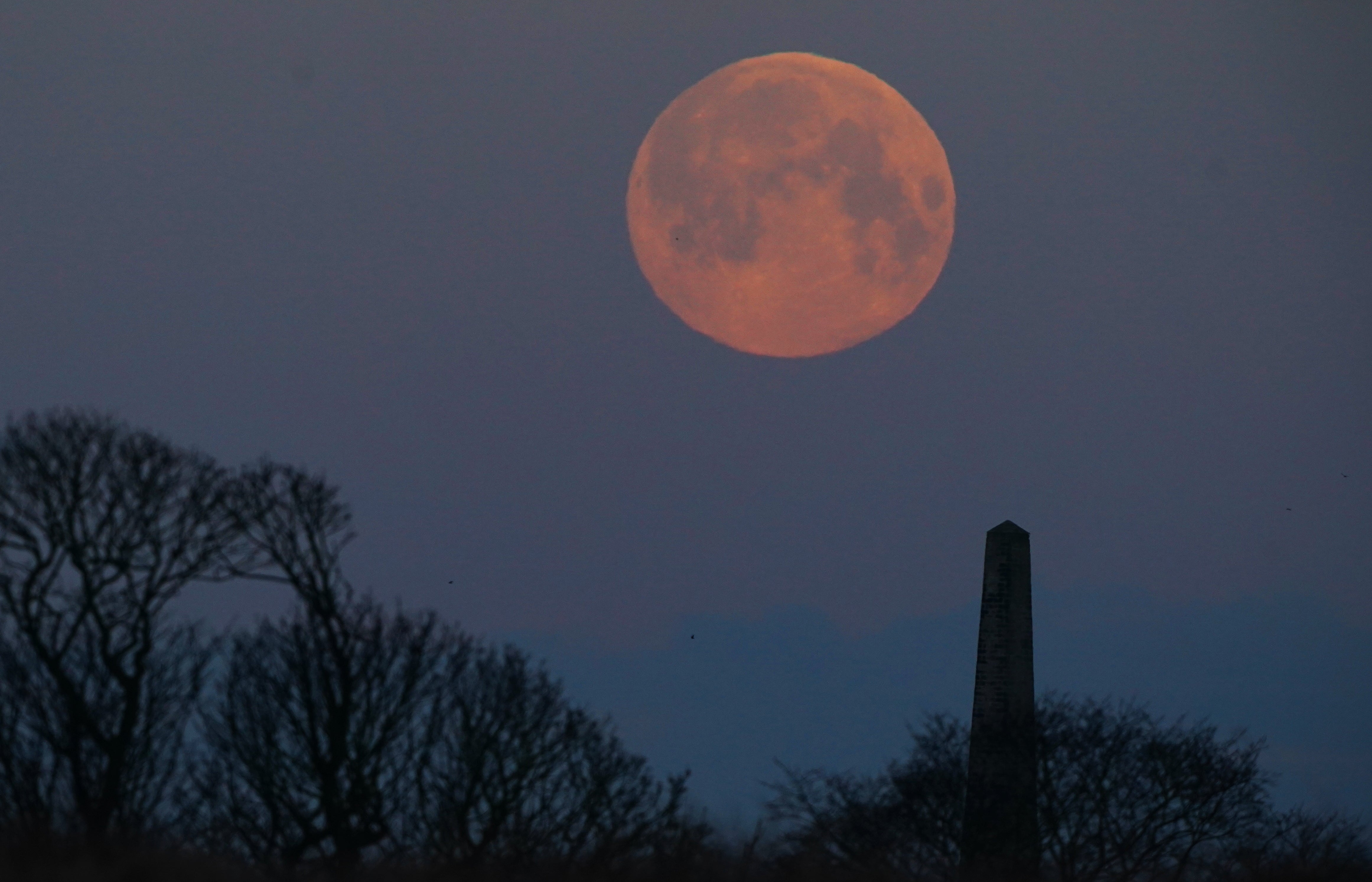 The full moon known as the 'Snow moon' sets over Whitley Bay in North Tyneside