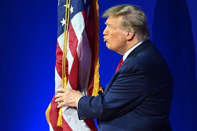 <p>Former US President and 2024 presidential hopeful Donald Trump kisses the US flag as he arrives to speak during the annual Conservative Political Action Conference (CPAC) meeting on February 24, 2024, in National Harbor, Maryland</p>