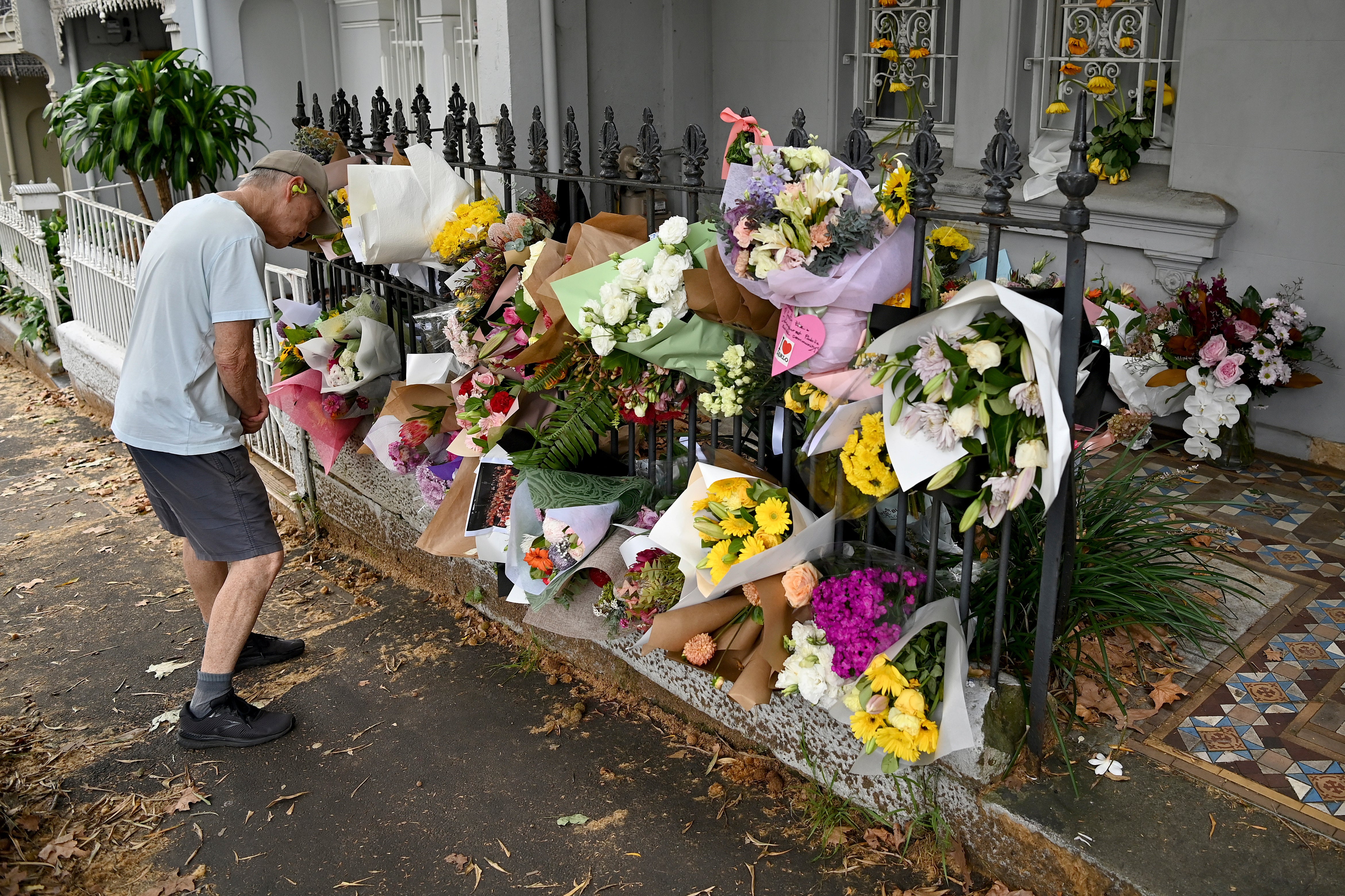 A man looks at floral tributes in Sydney, on Monday, at the Paddington residence of Jesse Baird