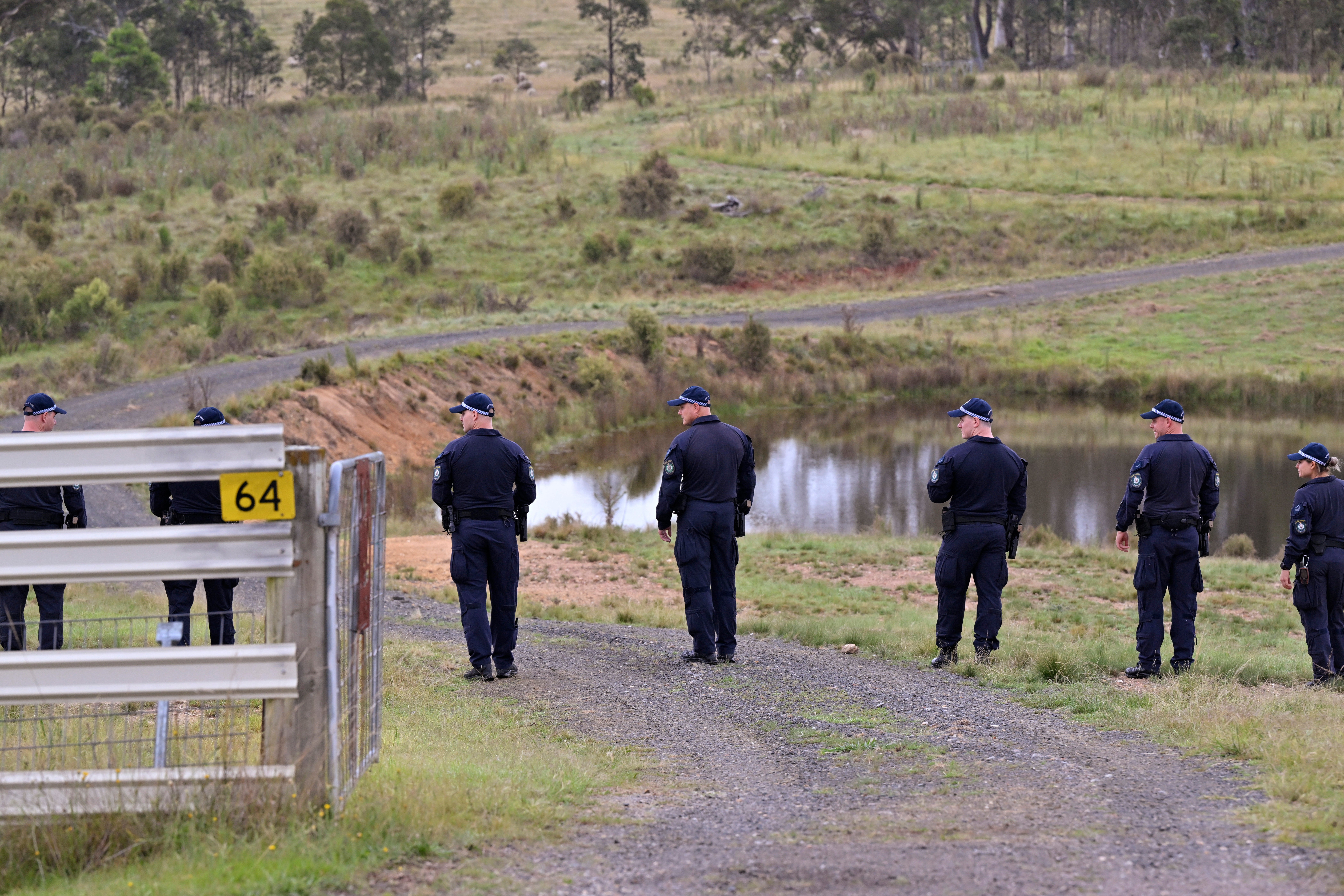 Police conduct a line search near a body of water on a rural property near Bungonia