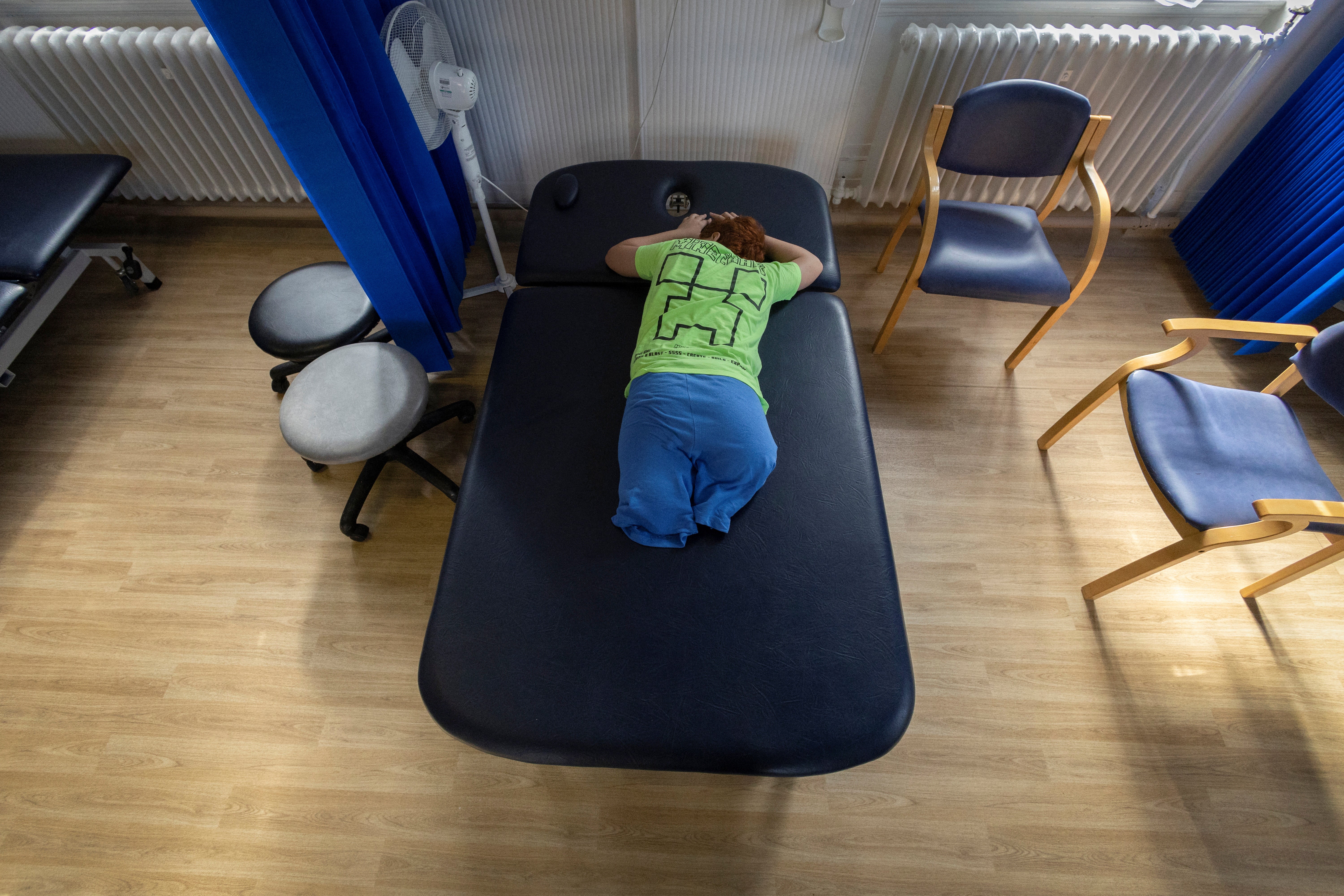 Mehmet, lies on a treatment bed at the hospital, as he waits to be seen