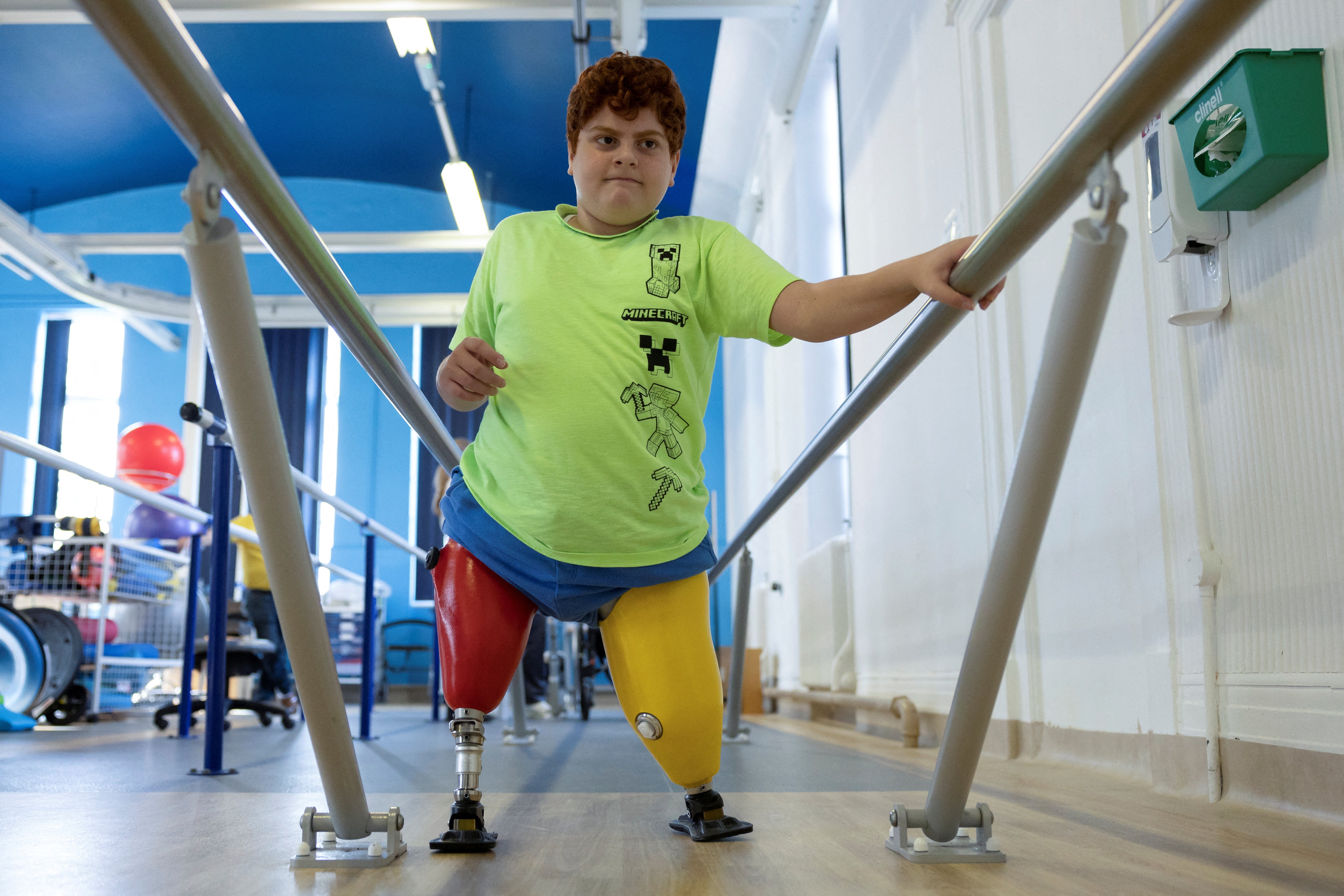 Mehmet, uses physiotherapy bars at the Royal National Orthopaedic Hospital during a prosthetics fitting session