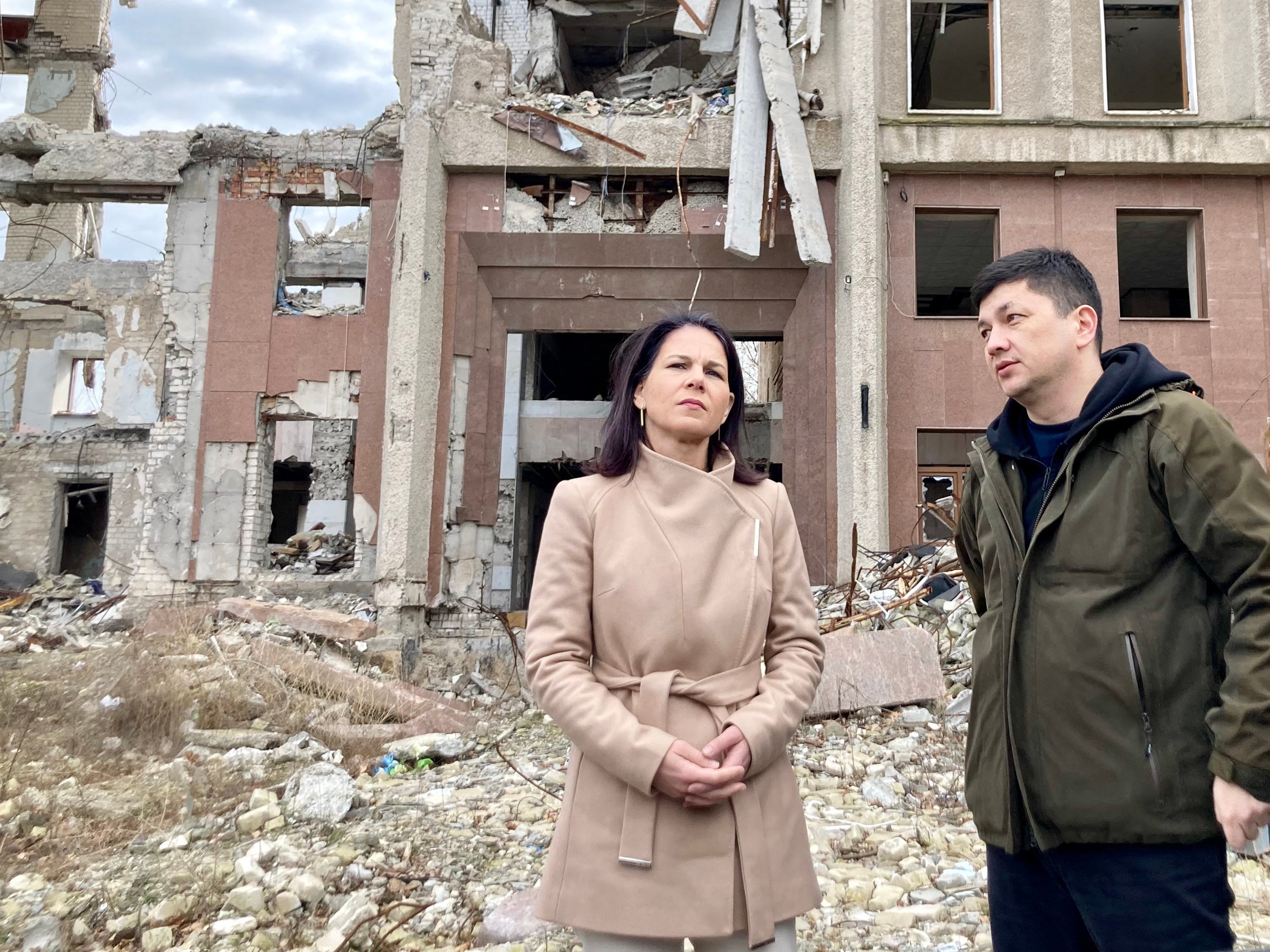 Germany's foreign minister Annalena Baerbock and Head of Mykolaiv Regional Military Administration Vitaliy Kim stand next to the destroyed administrative centre of Mykolaiv damaged by a strike in 2022