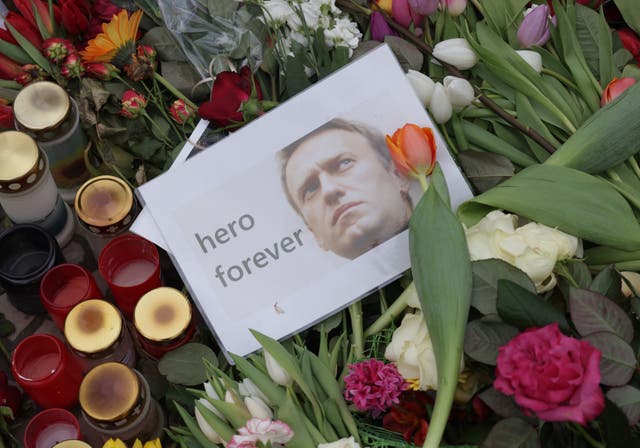 <p>A photo of Russian opposition figure Alexei Navalny that reads: “hero forever” lies among candles and flowers at a makeshift memorial to him in front of the Russian Embassy in Berlin</p>