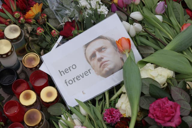 <p>A photo of Russian opposition figure Alexei Navalny that reads: “hero forever” lies among candles and flowers at a makeshift memorial to him in front of the Russian Embassy in Berlin</p>