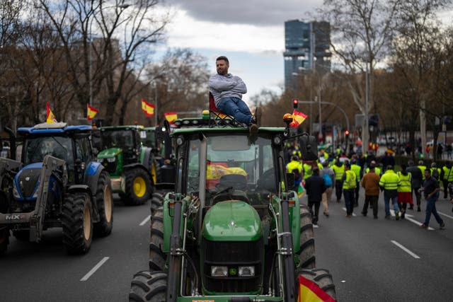 <p>A farmer sits atop a tractor during a protest outside the European Parliament offices in Madrid, Spain</p>