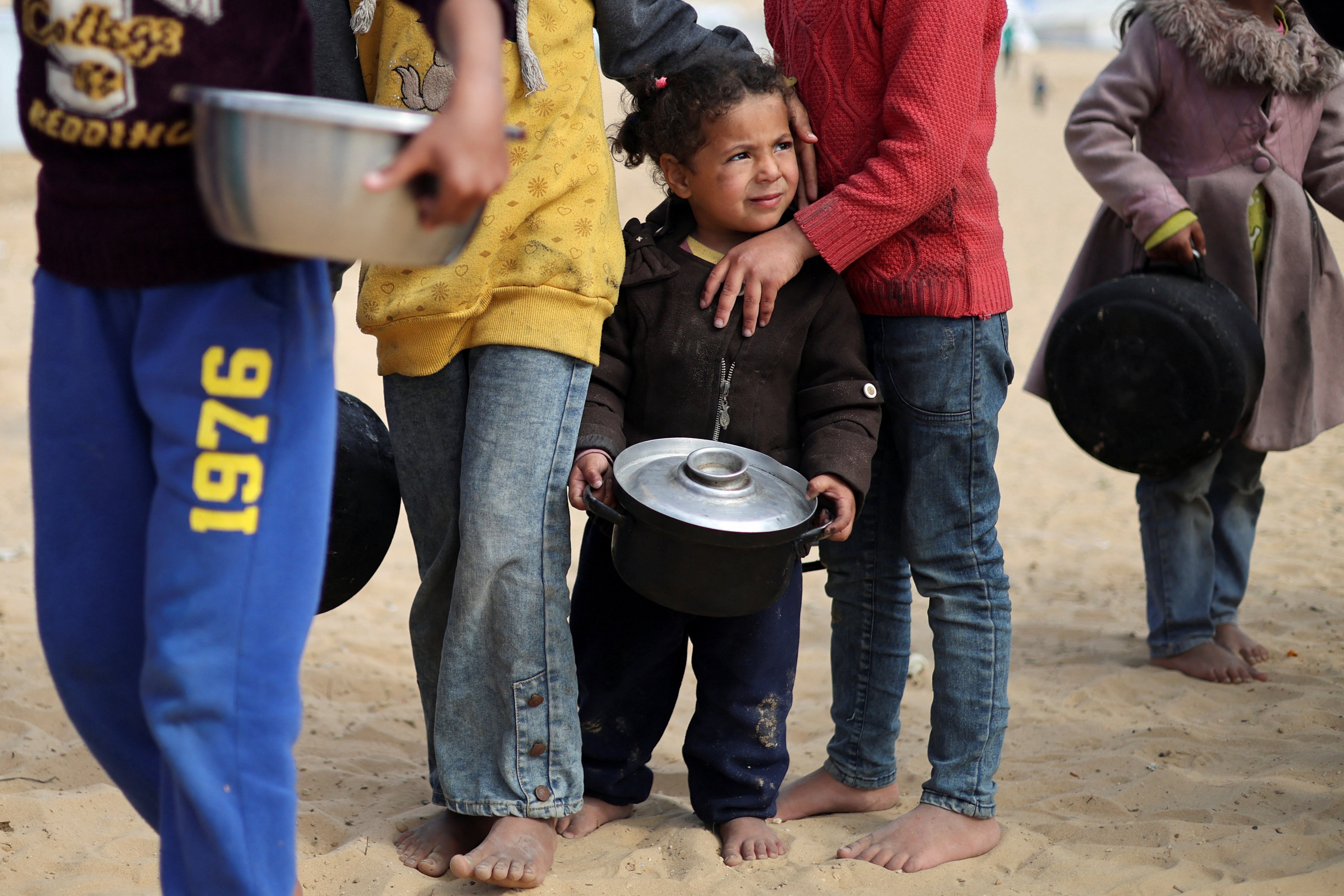 Displaced Palestinian children on Tuesday queue for food at a camp in Rafah