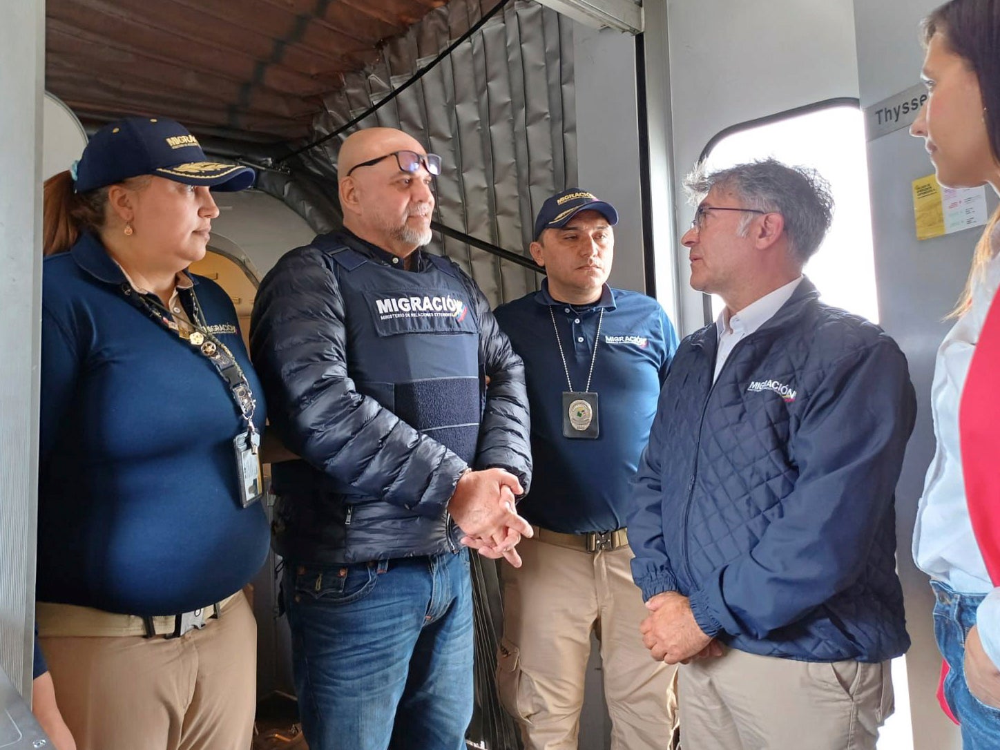 In this photo released by the Colombian Immigration agency, migration officials meet former Colombian paramilitary leader, Salvatore Mancuso, at the gate of the plane at El Dorado International Airport in Bogota, Colombia