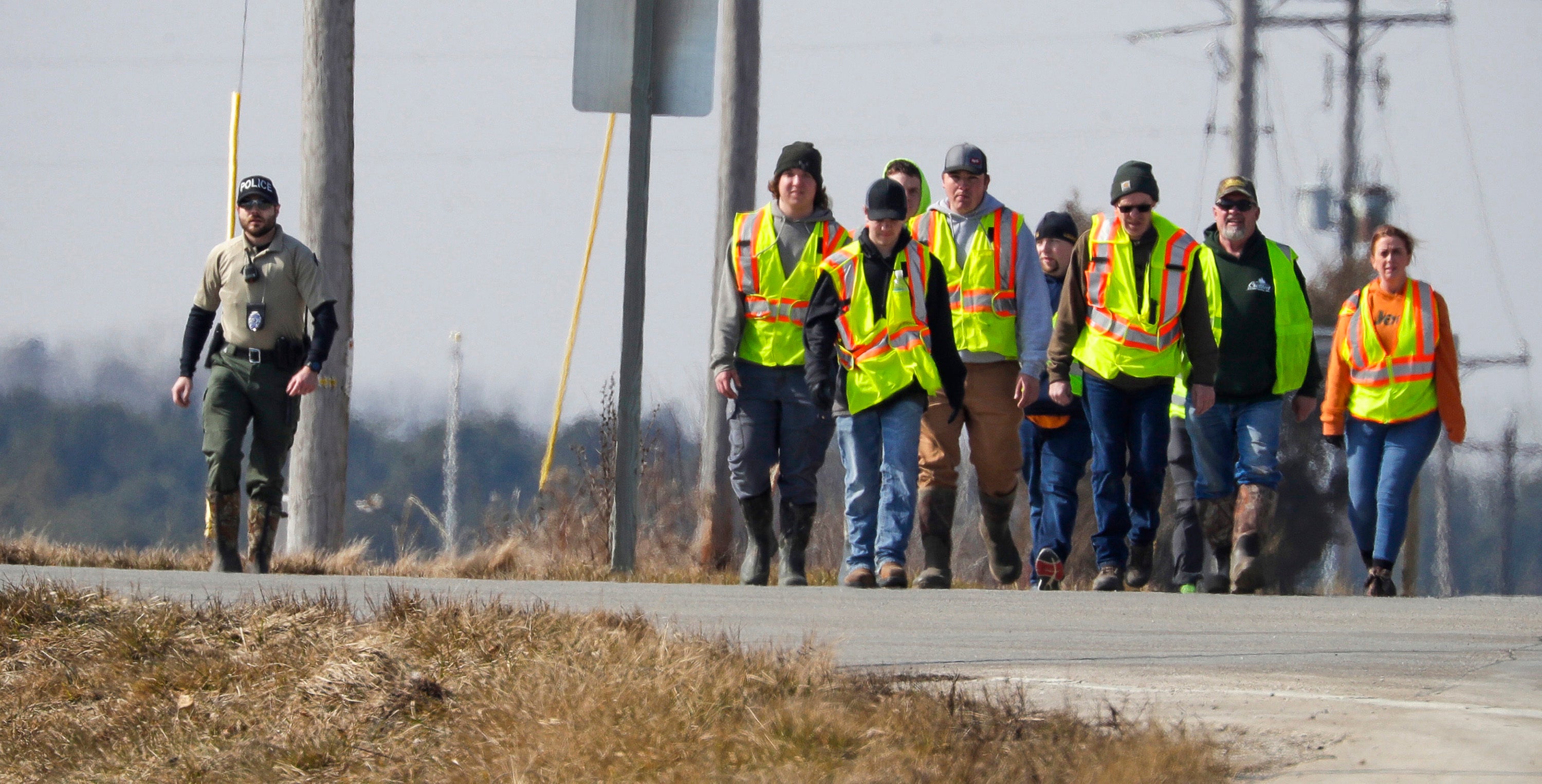 Police and area firefighters walk along state Highway 310 near Johnston Road during the search for missing three-year-old Elijah Vue on Tuesday 27 February