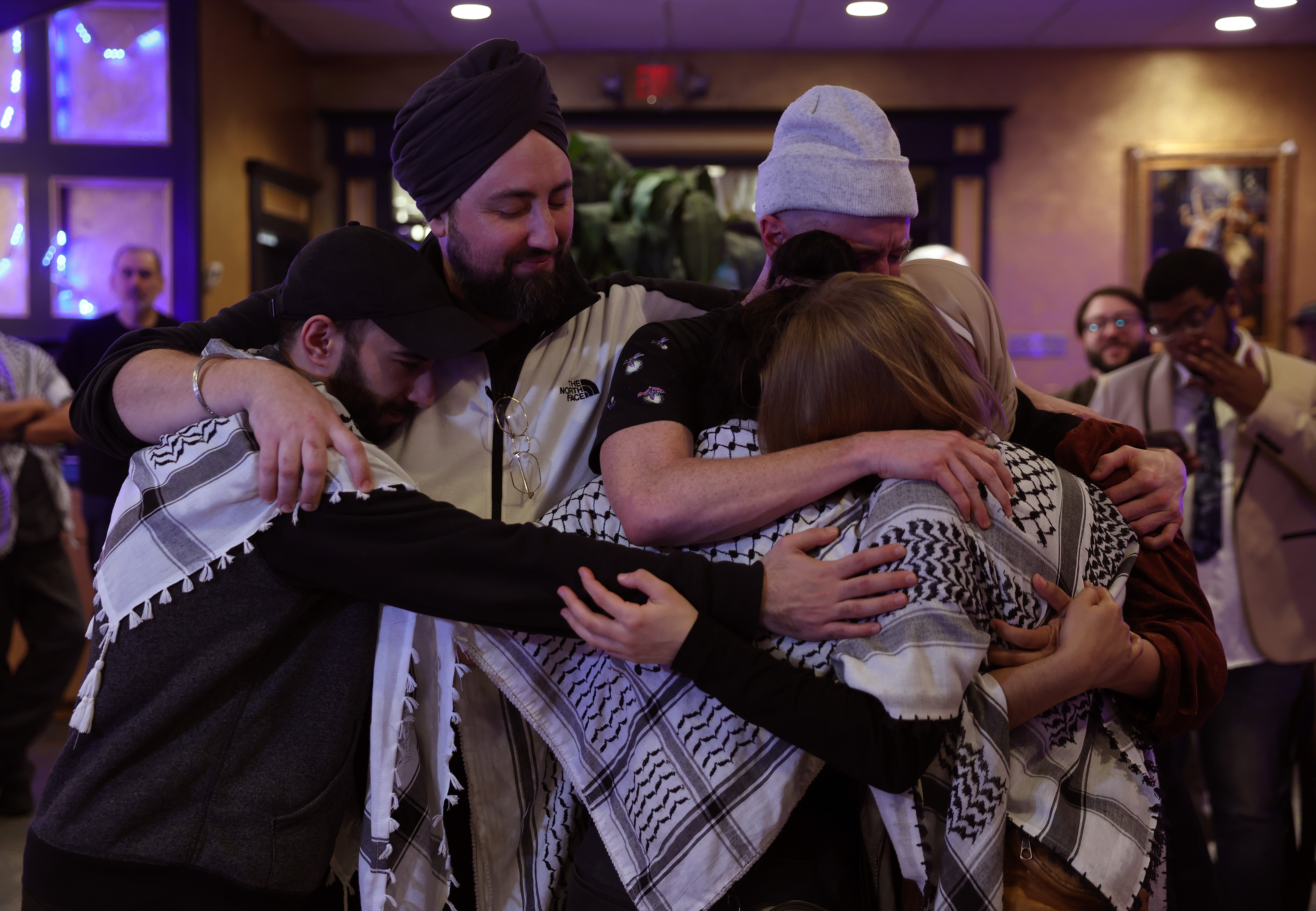 Attendees console each other during an "Uncommitted for Joe Biden" primary election night watch party at Adonis restaurant on February 27, 2024 in Dearborn, Michigan.