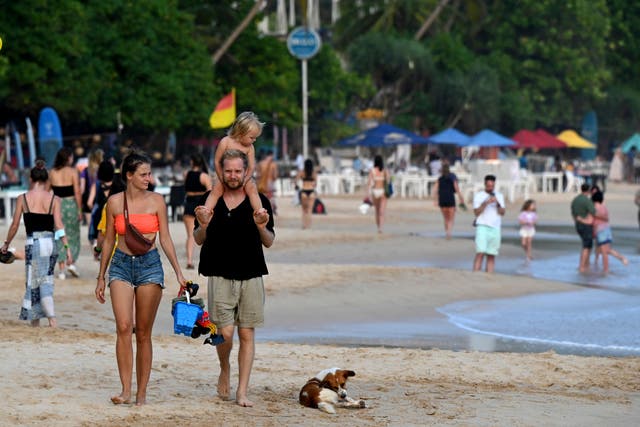 <p>Tourists walk along a beach in Mirissa in Sri Lanka</p>