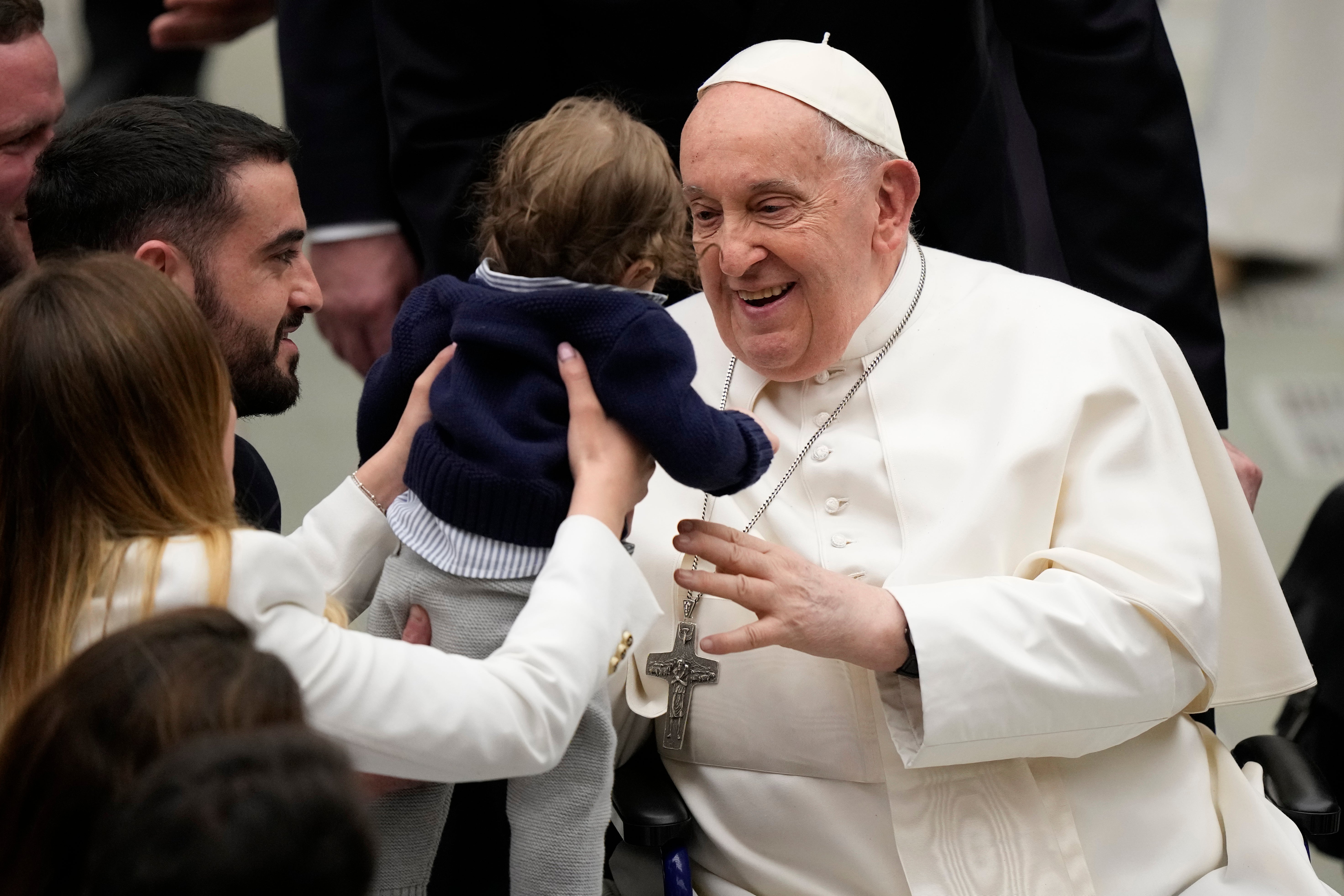 Pope Francis hugs a baby at the end of his weekly general audience in the Paul VI Hall, at the Vatican on Wednesday