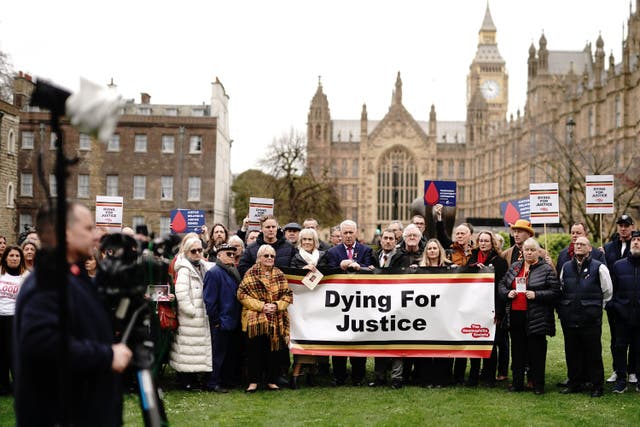 Infected blood victims and campaigners protest on College Green in Westminster (PA)