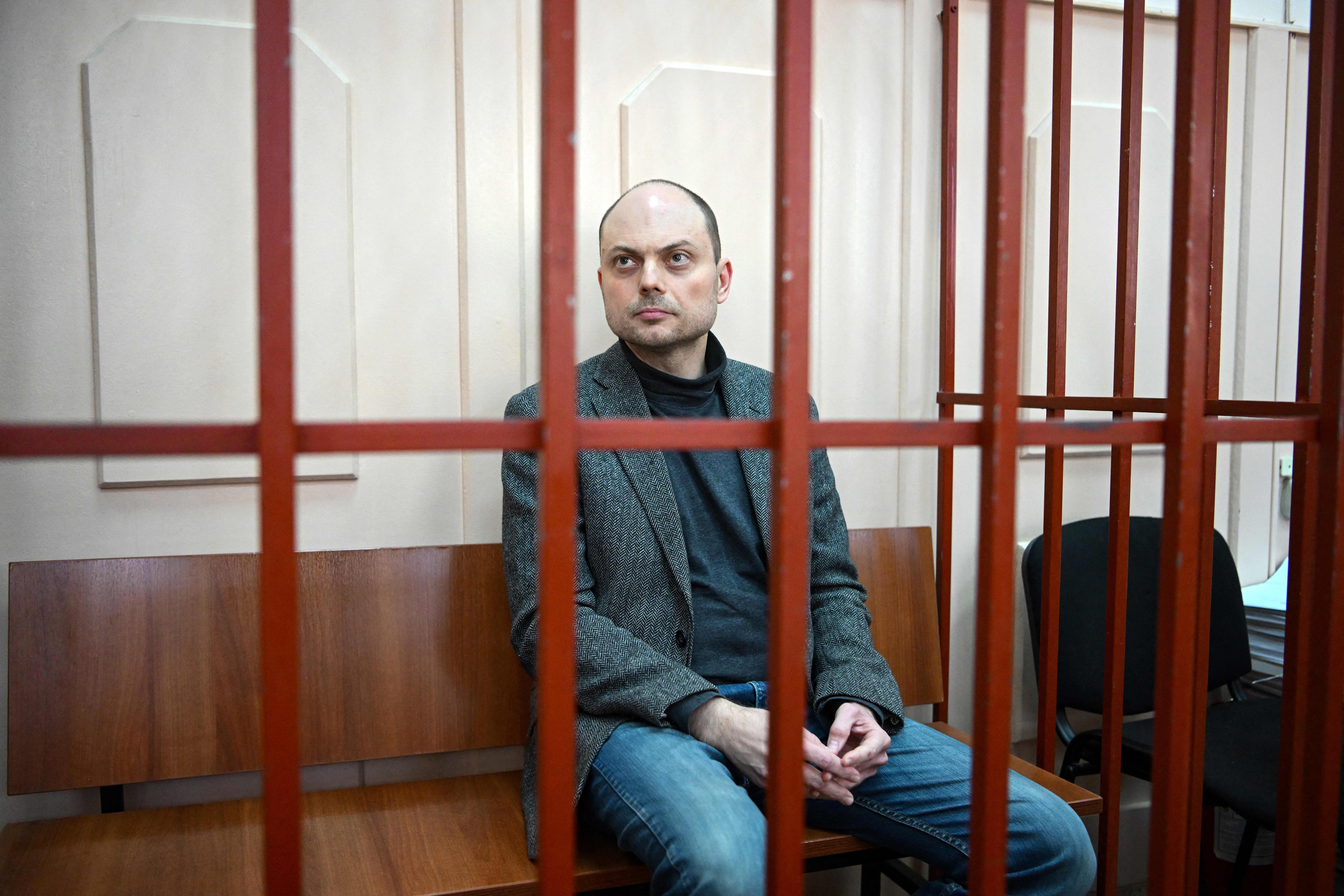 Russian opposition activist Vladimir Kara-Murza sits on a bench inside a defendants’ cage during a hearing at the Basmanny court in Moscow on October 10, 2022