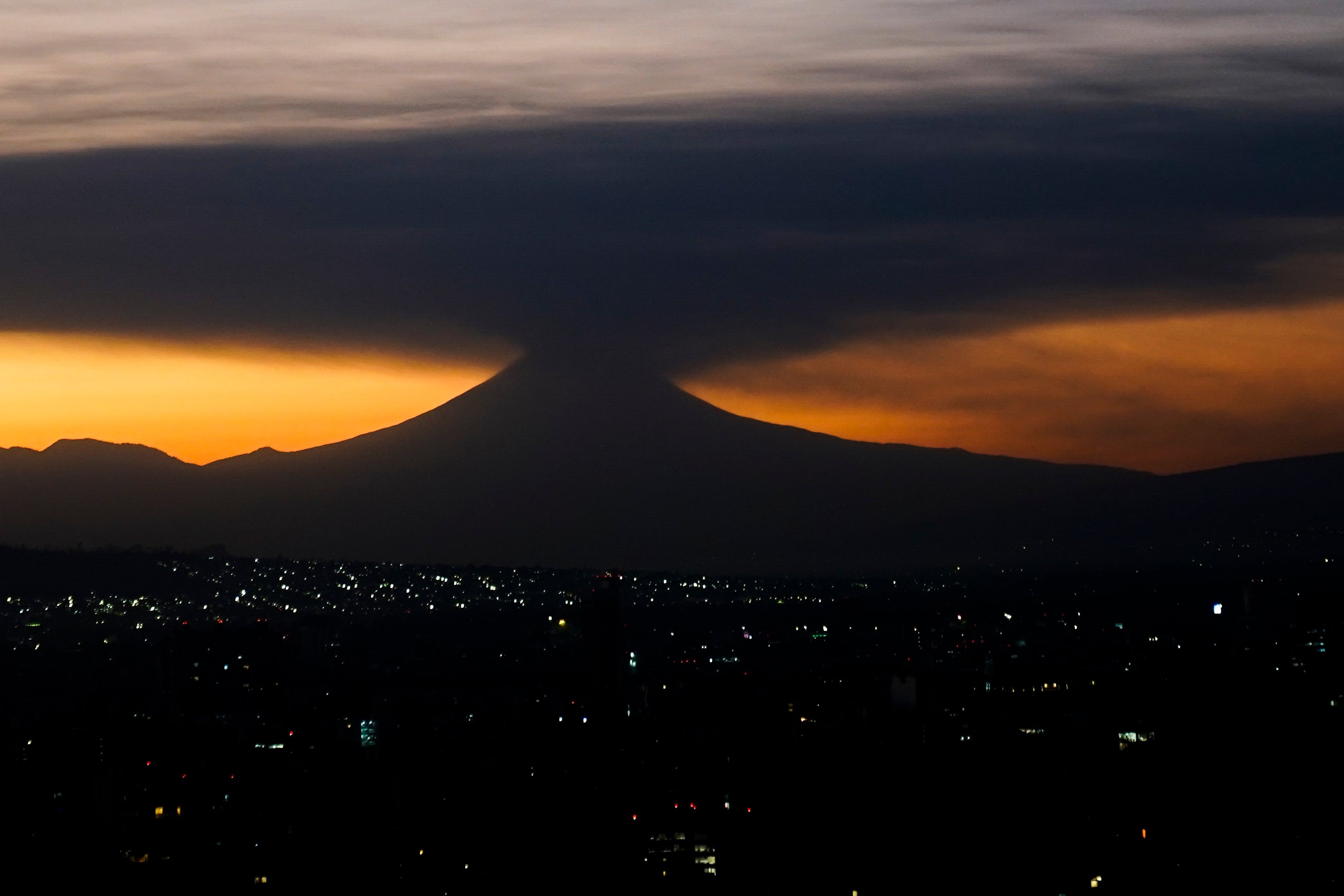 The Popocatepetl volcano emits smoke and ash, seen from Mexico City at sunrise on Tuesday, February 27, 2024