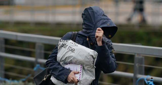 <p>File image: A woman battles through the windy conditions in Folkestone, Kent. Britons have been asked to brace for an unsettled weekend  </p>