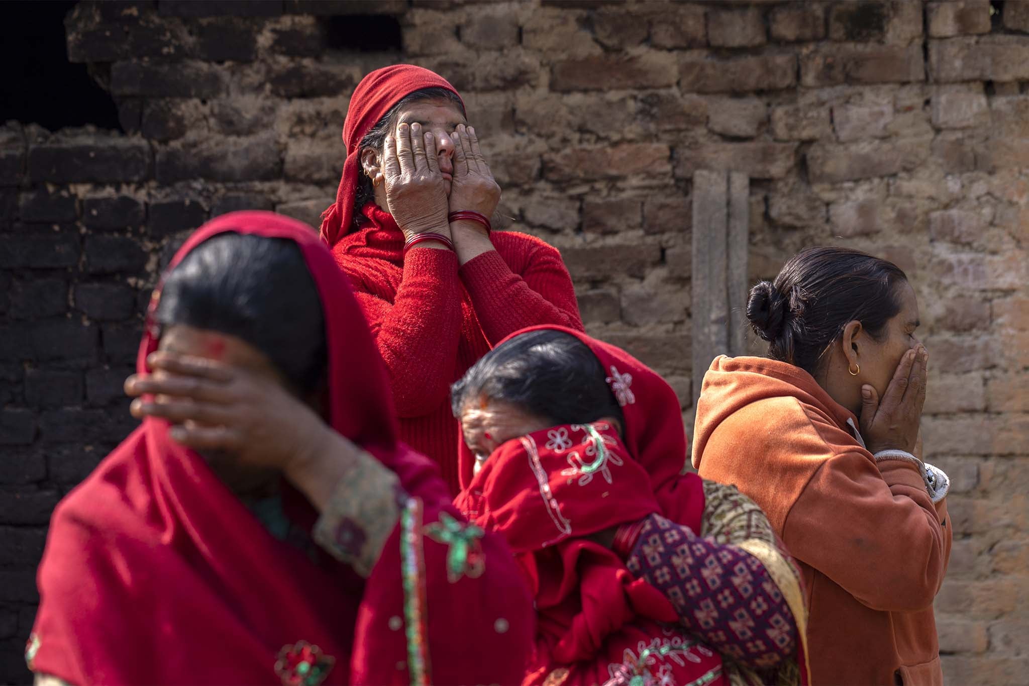 A group of women mourners cry during the final rites procession of Hari Aryal