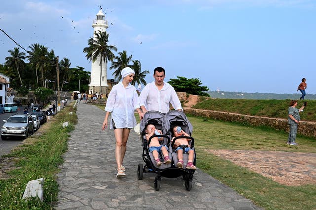 <p>Tourists walk by the coast in Galle, Sri Lanka</p>