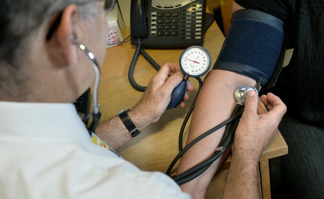 <p>A GP taking a blood pressure reading </p>