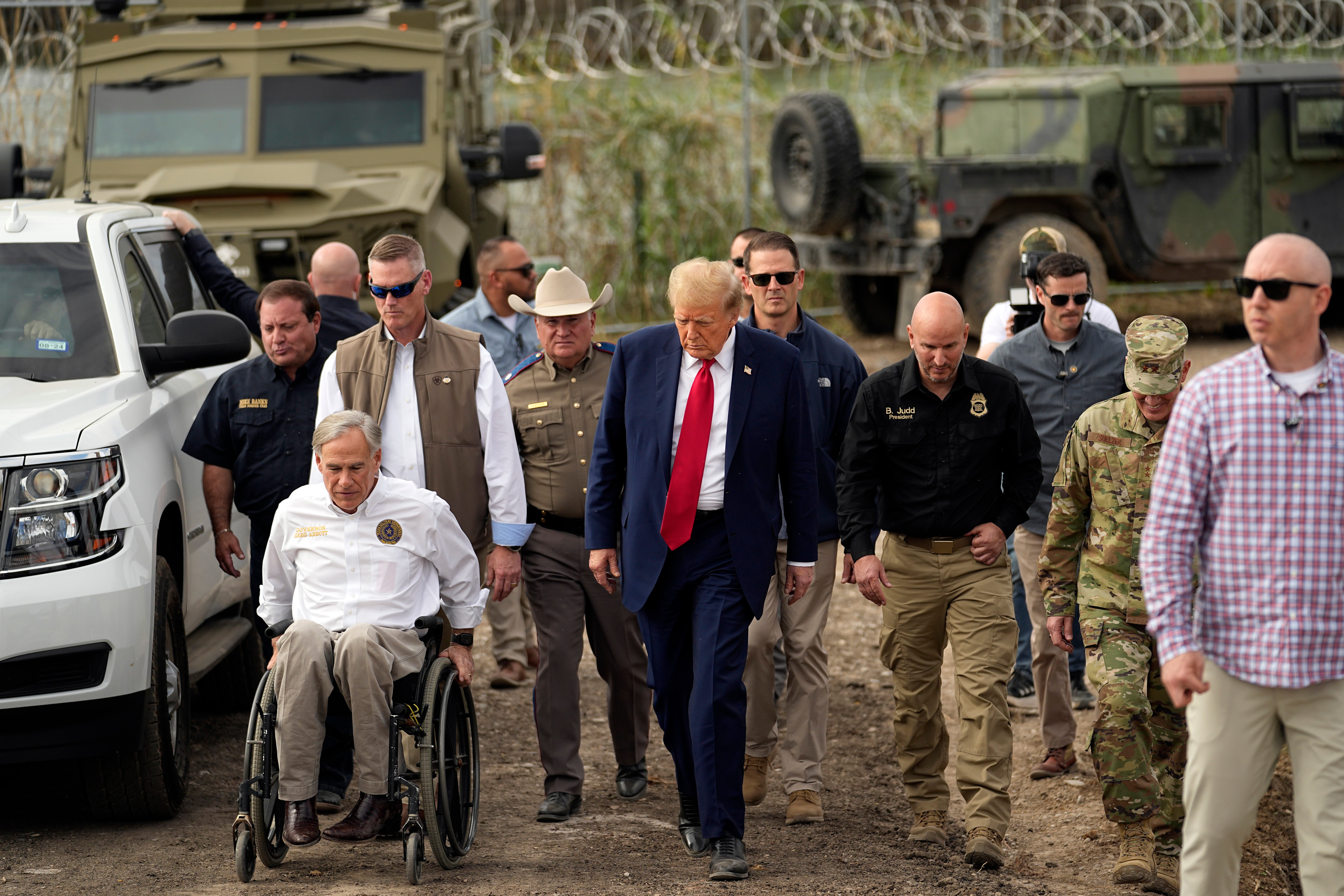 Donald Trump talks with Texas Governor Greg Abbott in Eagle Pass, Texas