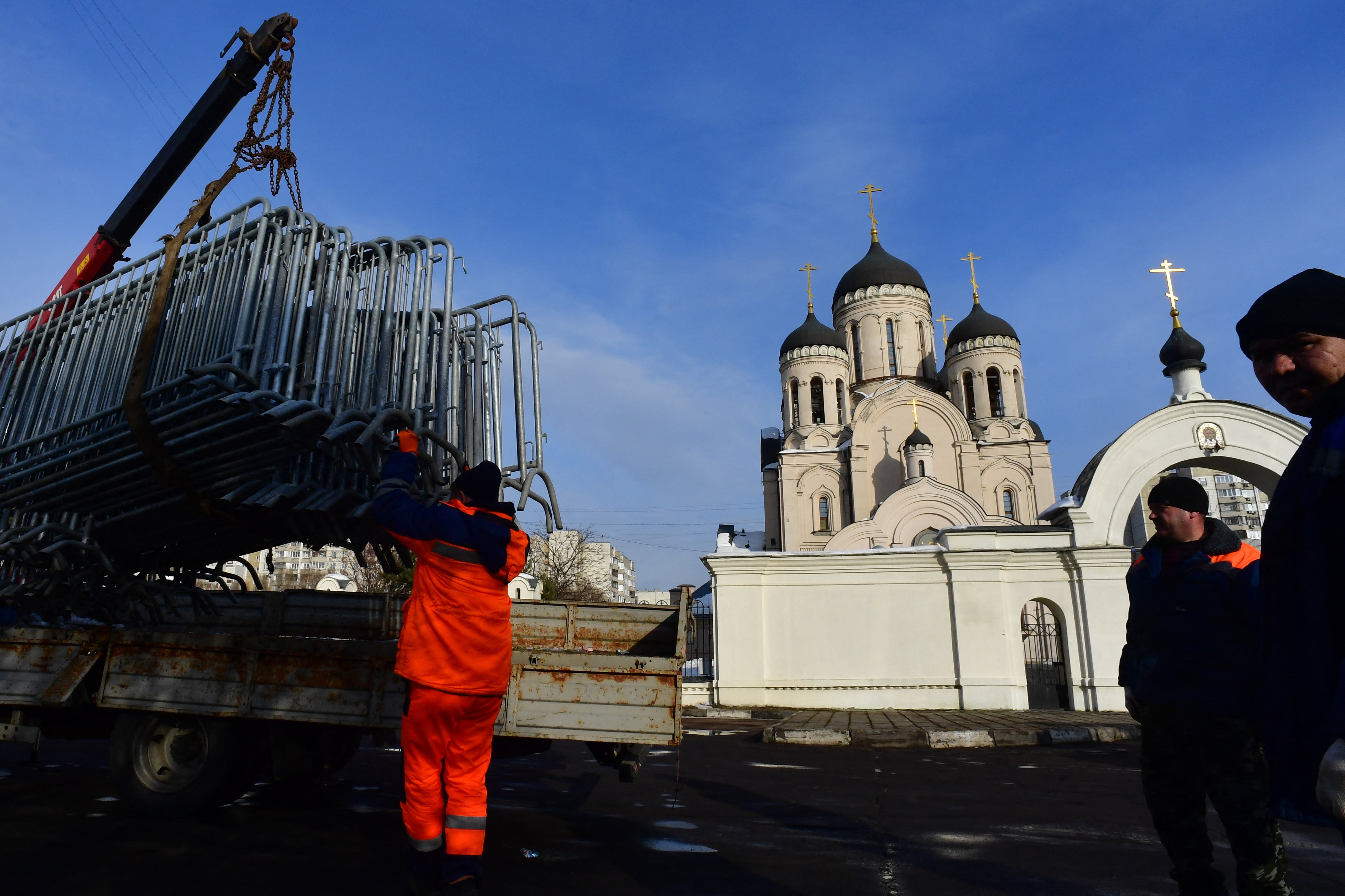 Workers unload metal fencing in front of a church in Moscow where Navalny’s funeral ceremony is set to take place