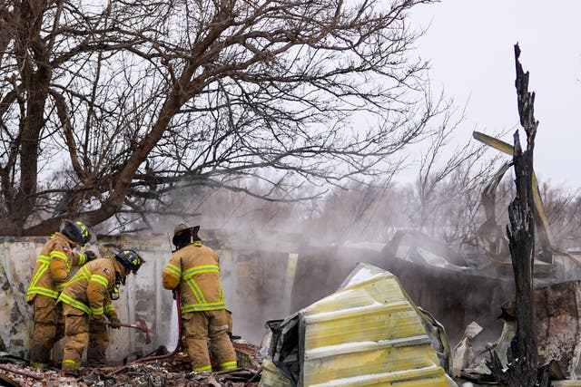 <p>Fire officials from Lubbock, Texas, help put out smoldering debris of a home destroyed by the Smokehouse Creek Fire</p>