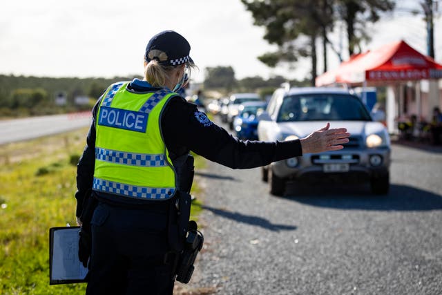 <p>Representative: A member of the police force inspects cars in Perth on 29 June 2021 </p>