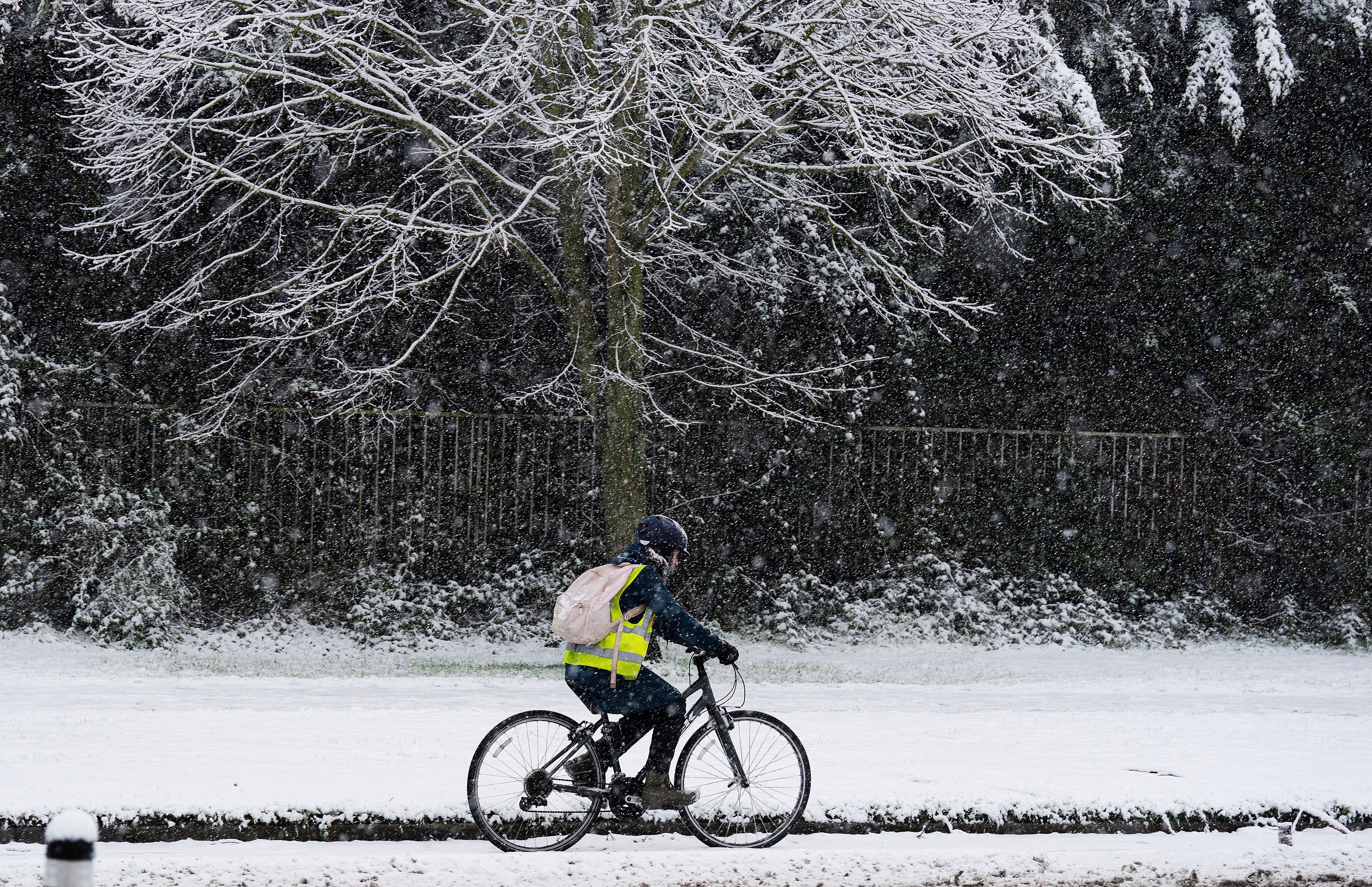 A cyclist on Griffith Avenue as snow falls on the Northside of Dublin