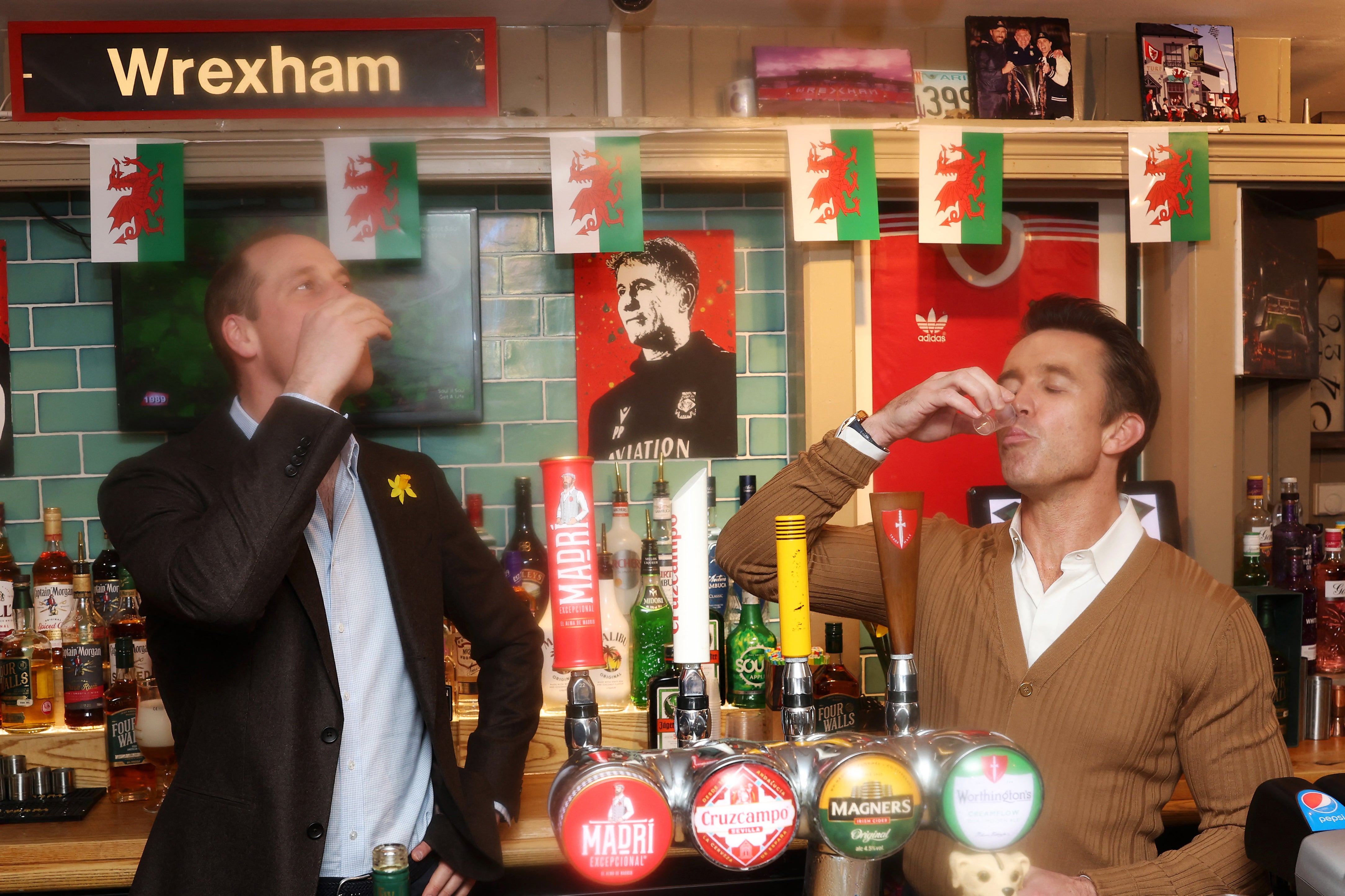 Britain’s Prince William, Prince of Wales (L) and co-chairman of Wrexham AFC Rob McElhenney (R) take a drink during a Royal visit
