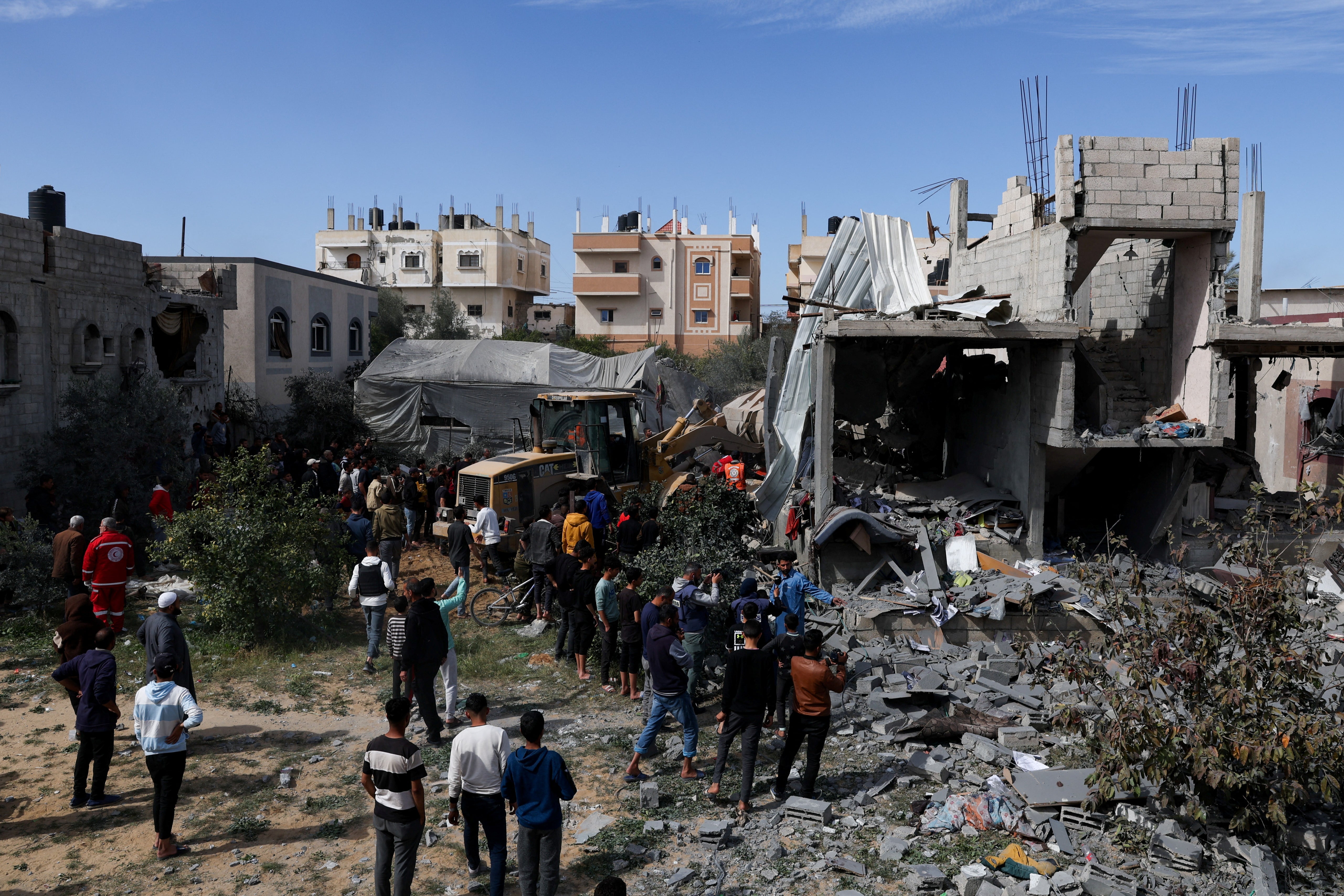 Palestinians gather at the site of an Israeli strike on a house in Rafah, southern Gaza