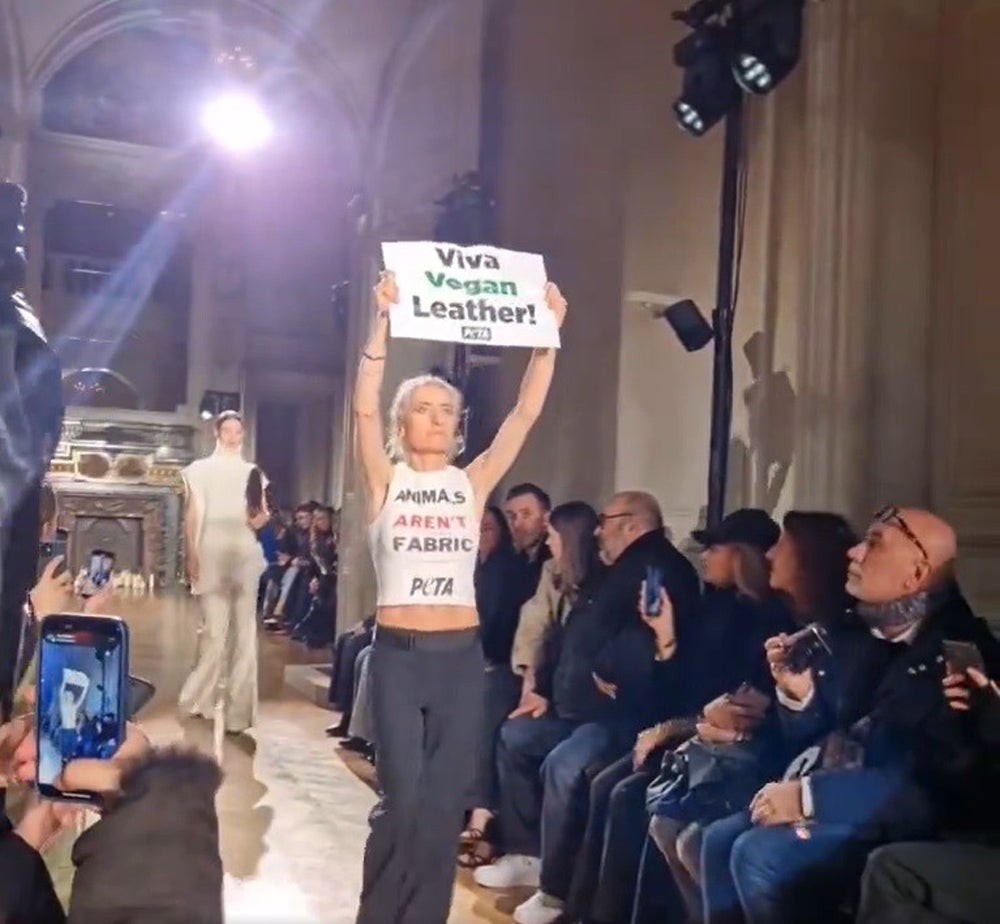 An activist disrupting Victoria Beckham's show at Paris Fashion Week in 2024