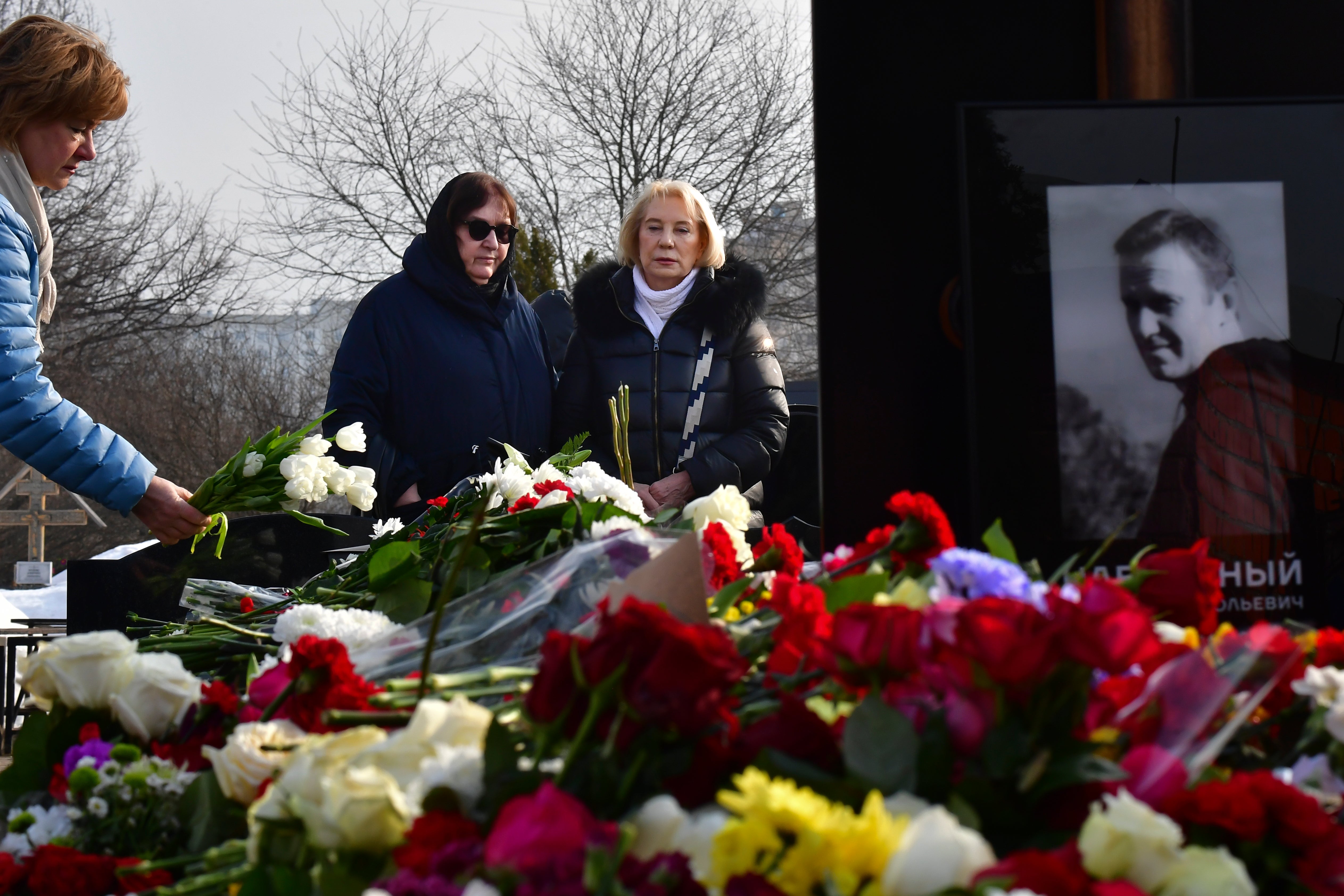 Russian opposition leader Alexei Navalny's mother, Lyudmila Navalnaya, left, and his mother-in-law, no name available, visit the grave of Alexei Navalny after his yesterday